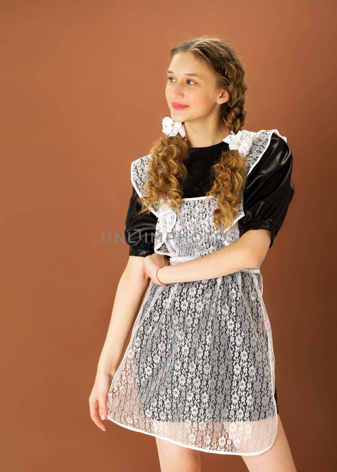 Cheerful blonde teen girl in retro school uniform by kolesnikov_studio