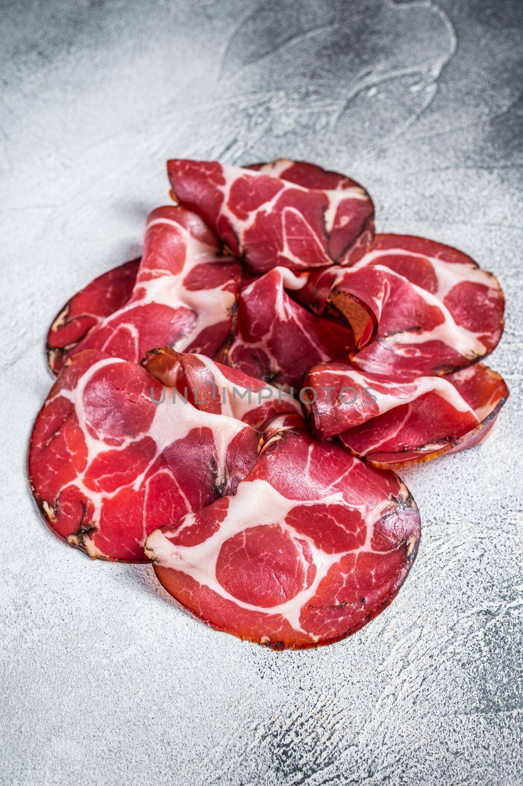 Coppa Cured ham on kitchen table. White background. Top view.