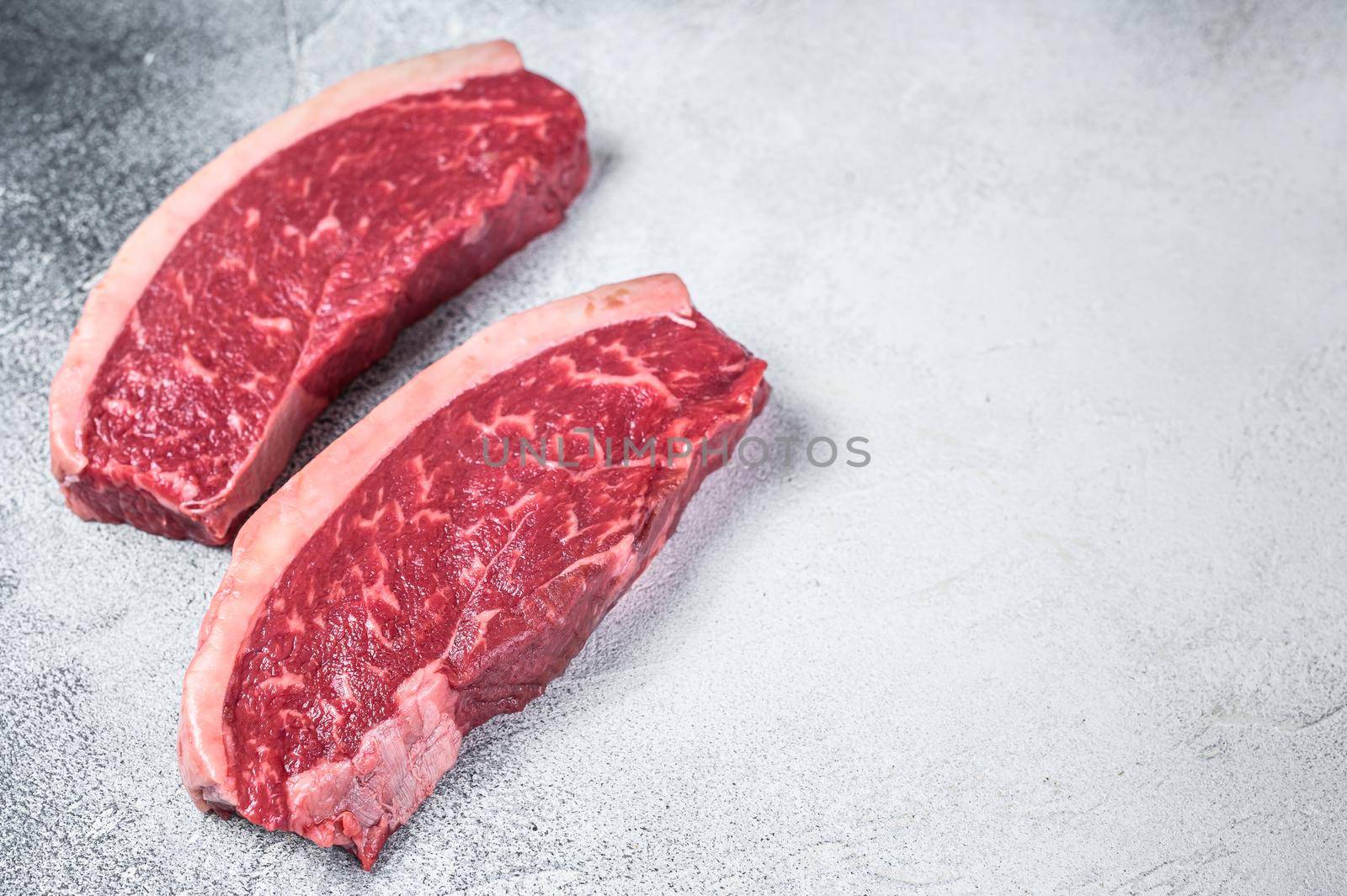 Raw cap rump or top sirloin beef meat steak. White background. Top view. Copy space.