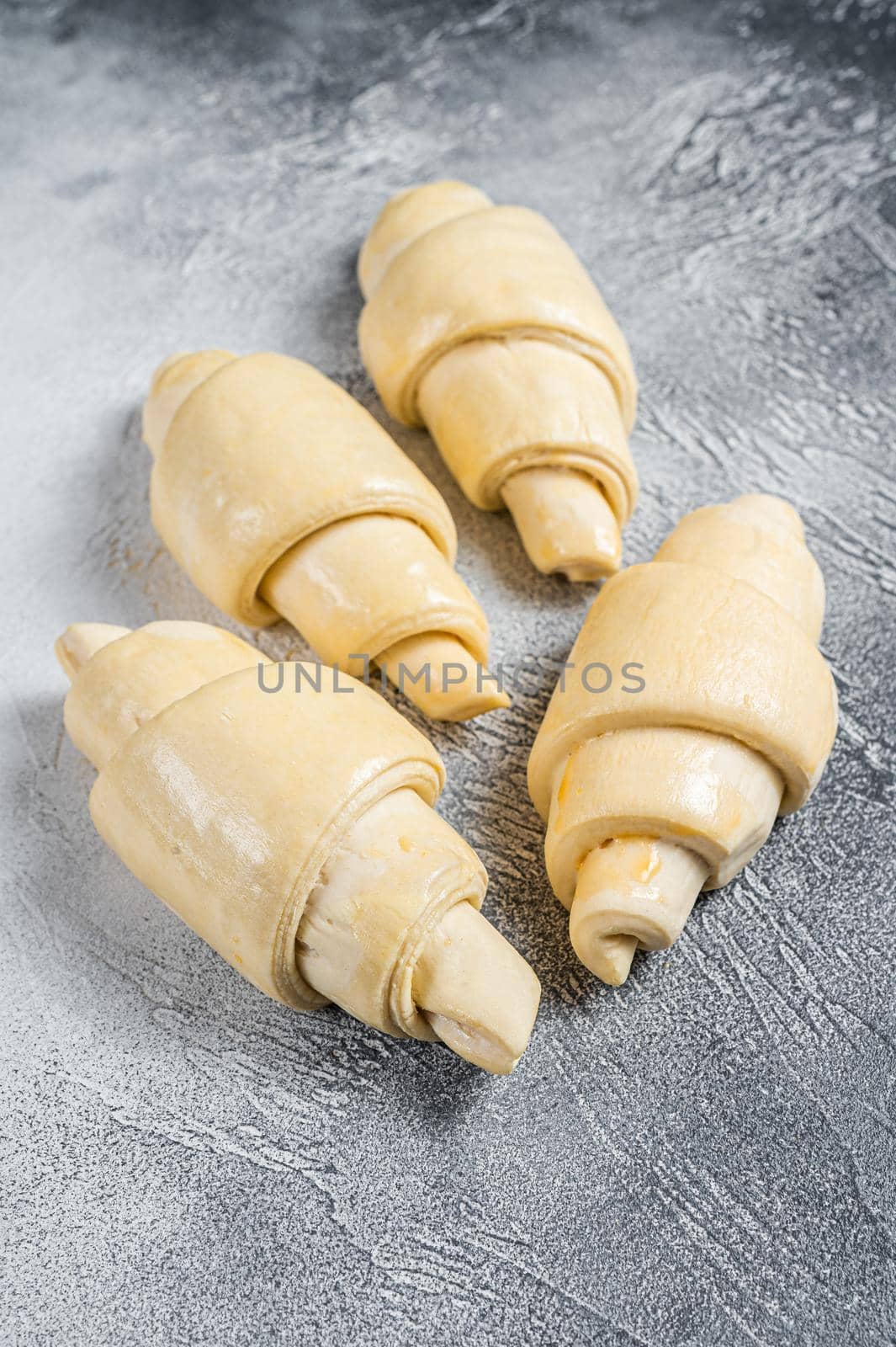 Raw unbaked croissant on kitchen table. White background. Top view.