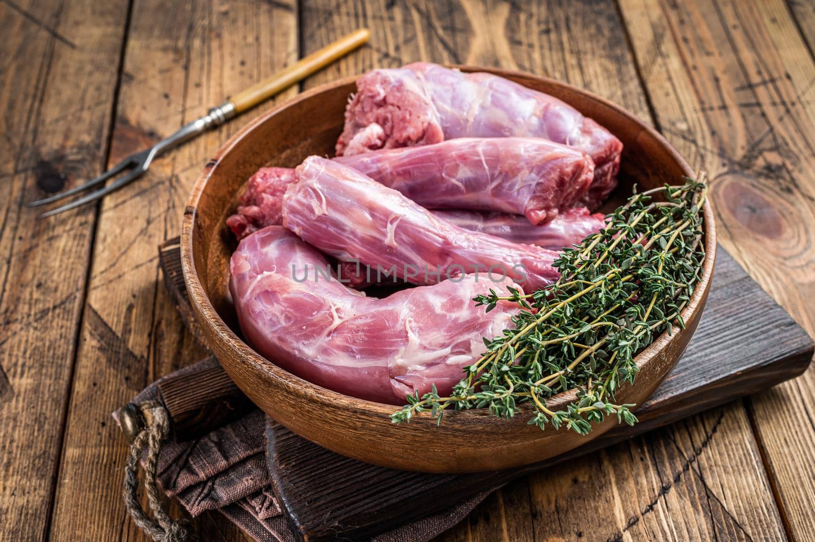 Fresh Raw Turkey necks meat in a wooden plate with thyme. wooden background. Top View.