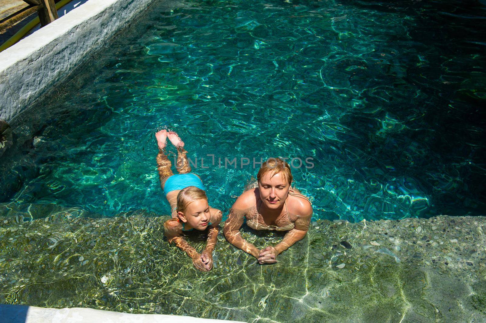 A happy family takes in a hydrogen sulfide treatment pool at a resort in Turkey by Lobachad