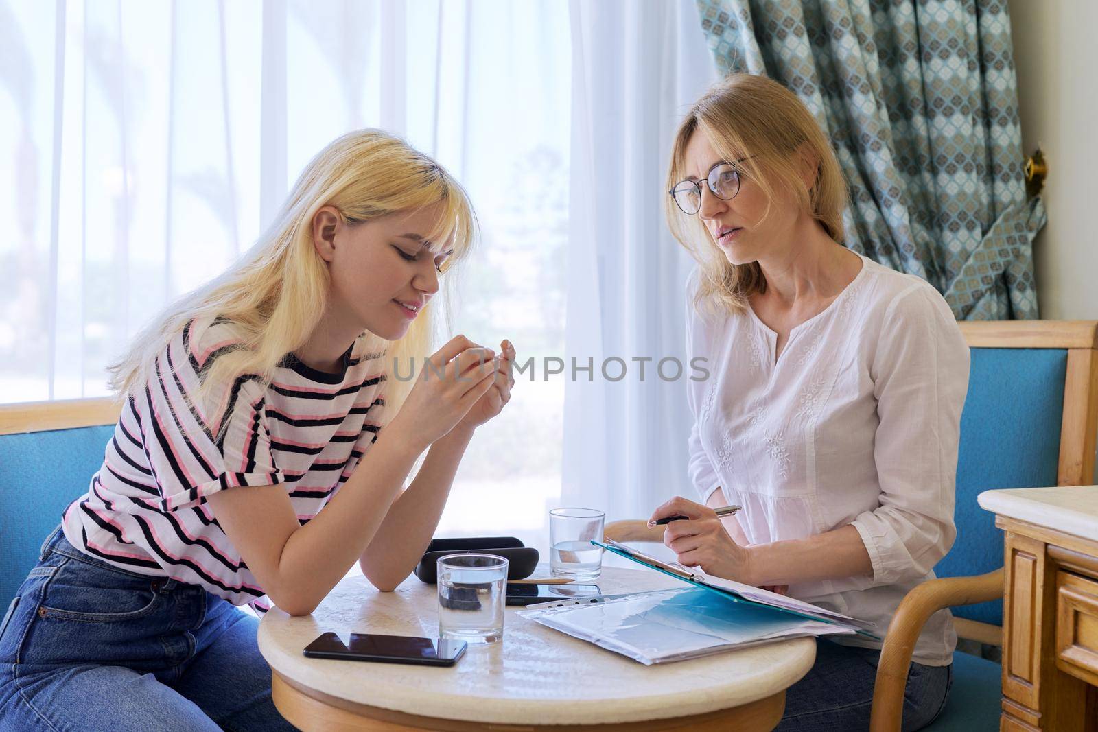 Female psychologist working with sad upset teenage girl, session in office. Adolescent depression, adolescent mental difficulties, professional psychological assistance, therapy, psychology