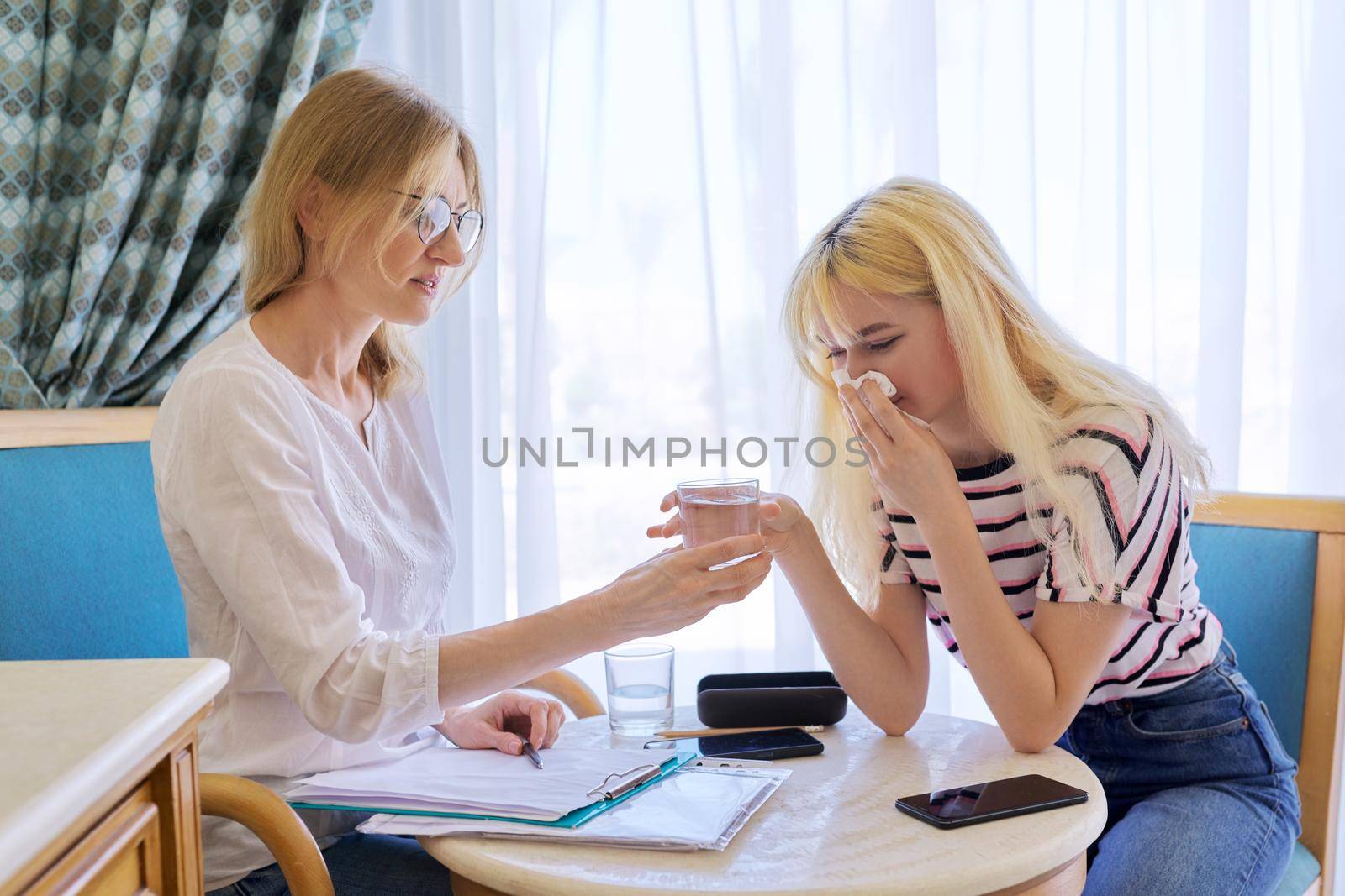 Female psychologist working with sad upset teenage girl, session in office. Adolescent depression, adolescent mental difficulties, professional psychological assistance, therapy, psychology