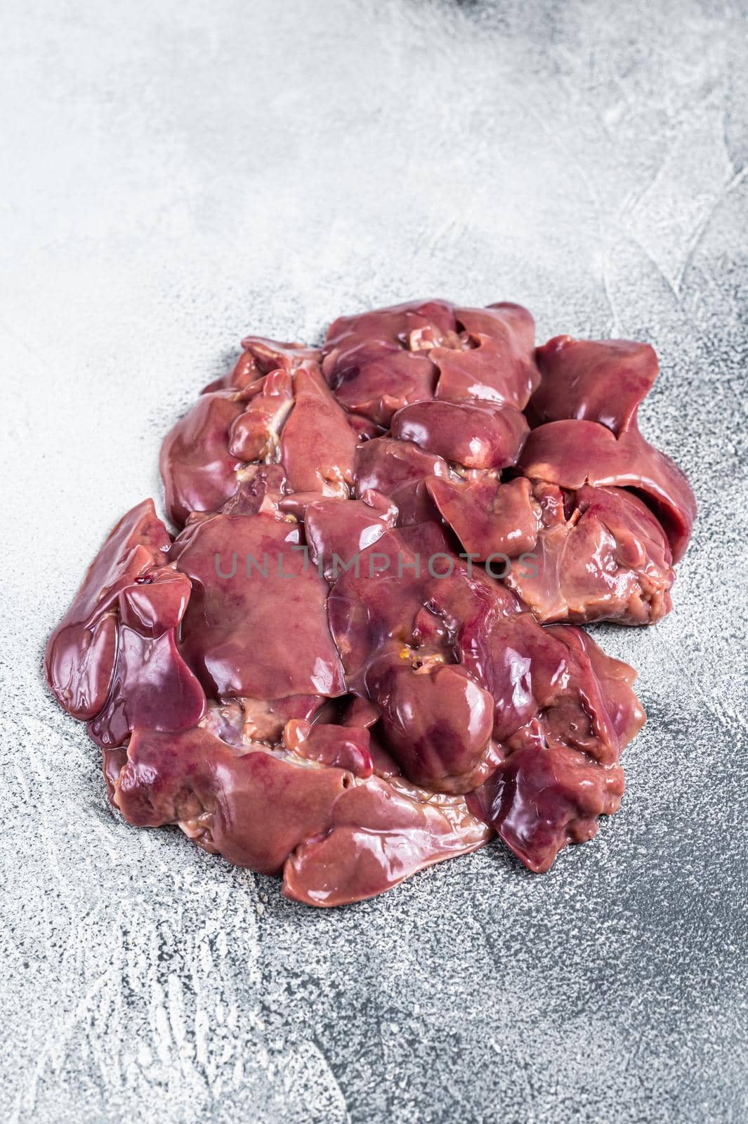 Raw chicken liver meat on butcher table. White background. Top view.