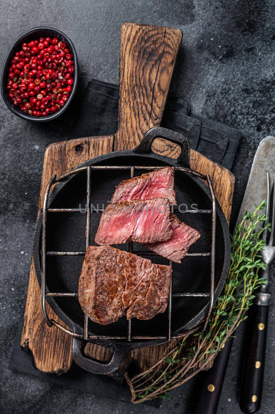 Grilled fillet mignon beef steak on a grill. Black background. Top view by Composter