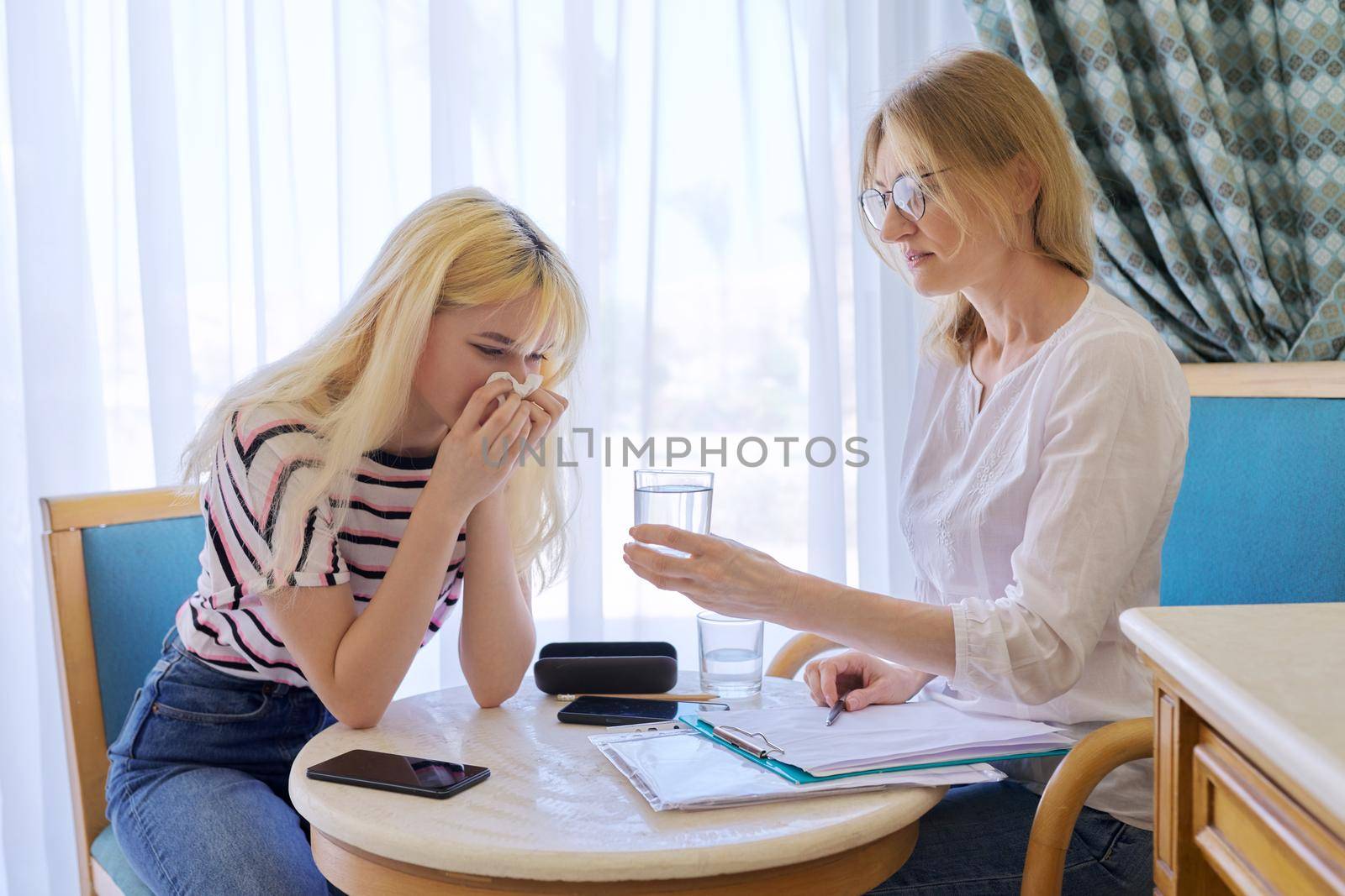 Female psychologist working with sad upset teenage girl, session in office. Adolescent depression, adolescent mental difficulties, professional psychological assistance, therapy, psychology