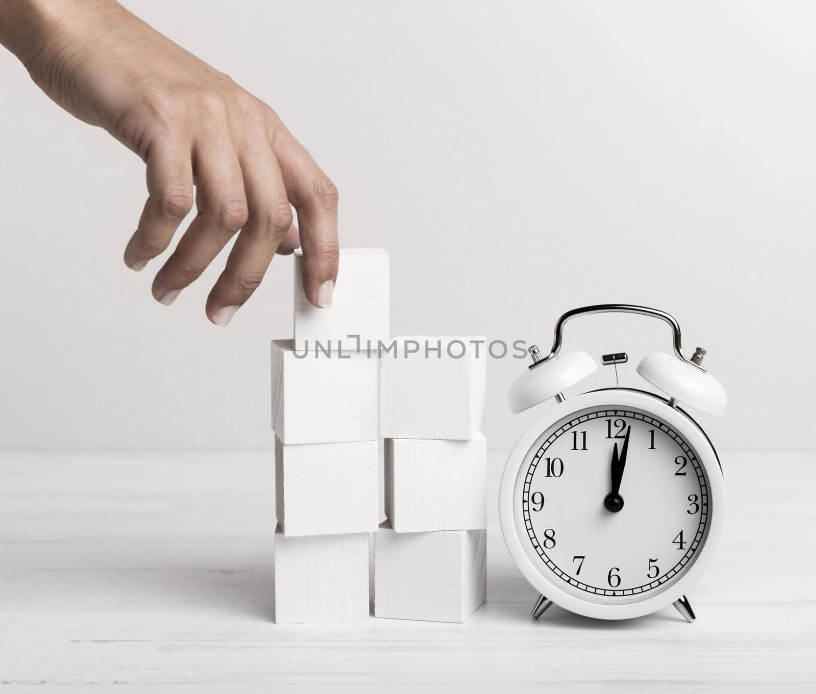 hand putting white cubes clock