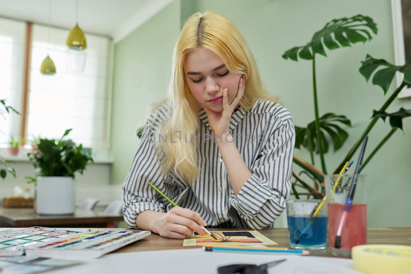 Teenager girl painting at home with watercolors by VH-studio