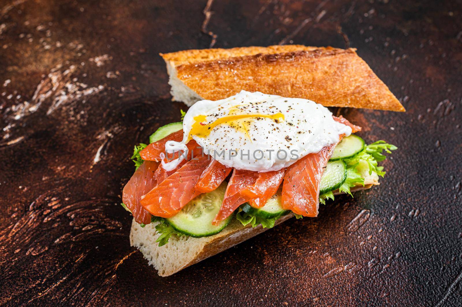 Poached egg with smoked salmon and avocado on toast. Dark background. Top view by Composter