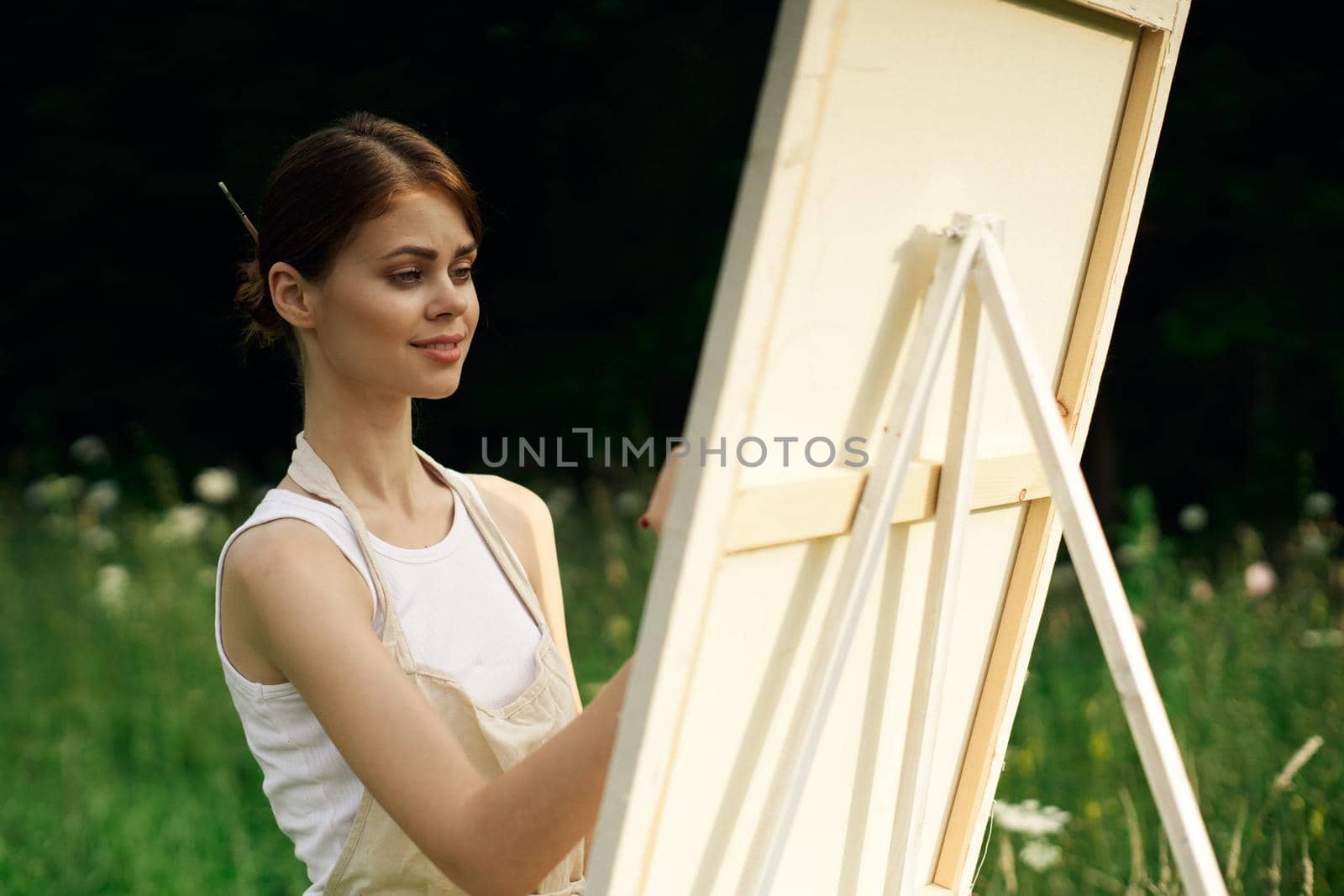 woman artist paints a picture near easel outdoors landscape creative. High quality photo