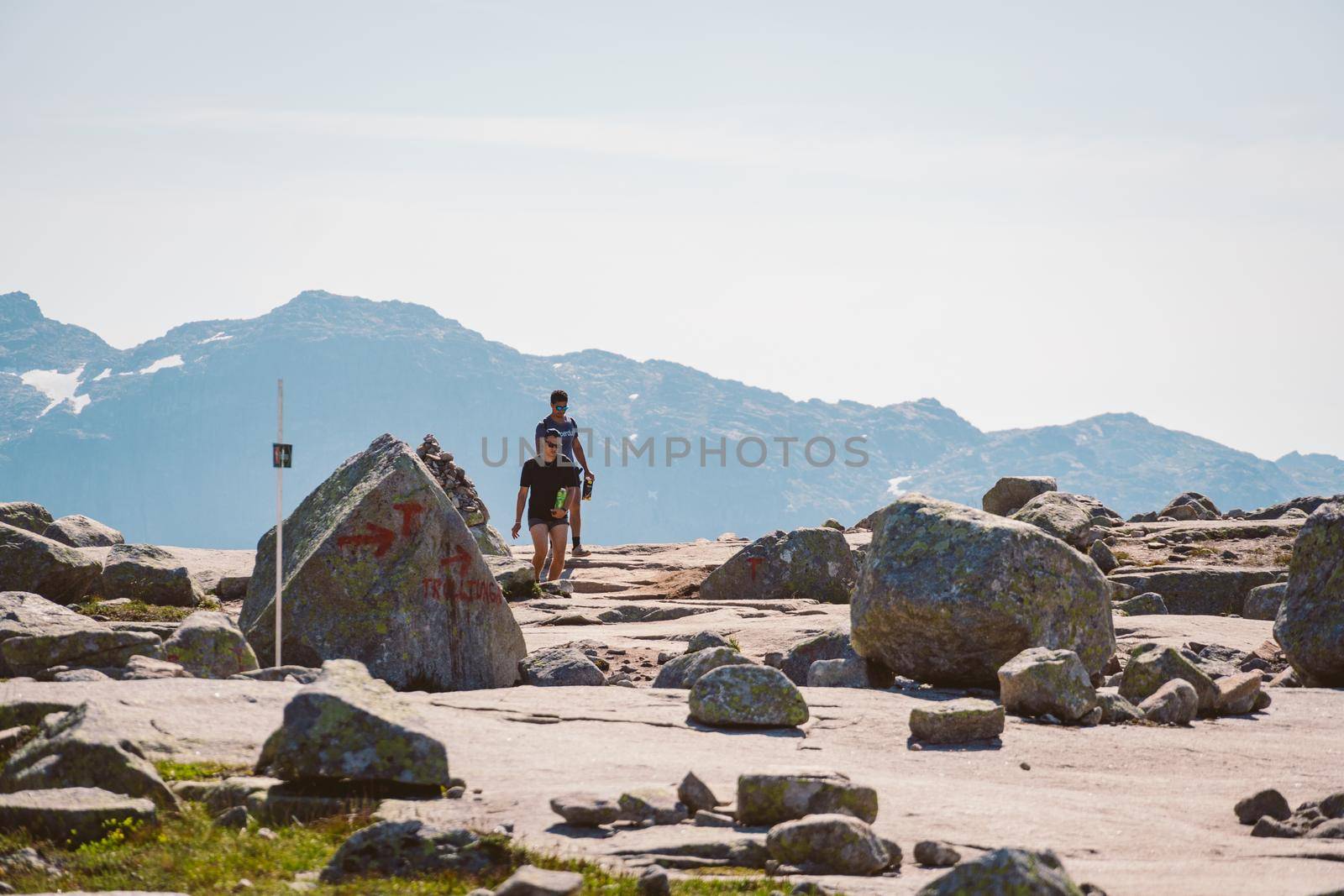 July 26, 2019. Norway tourist route on the trolltunga. People tourists go hiking in the mountains of Norway in fine sunny weather to thetrolltunga. Hiking backpack theme.