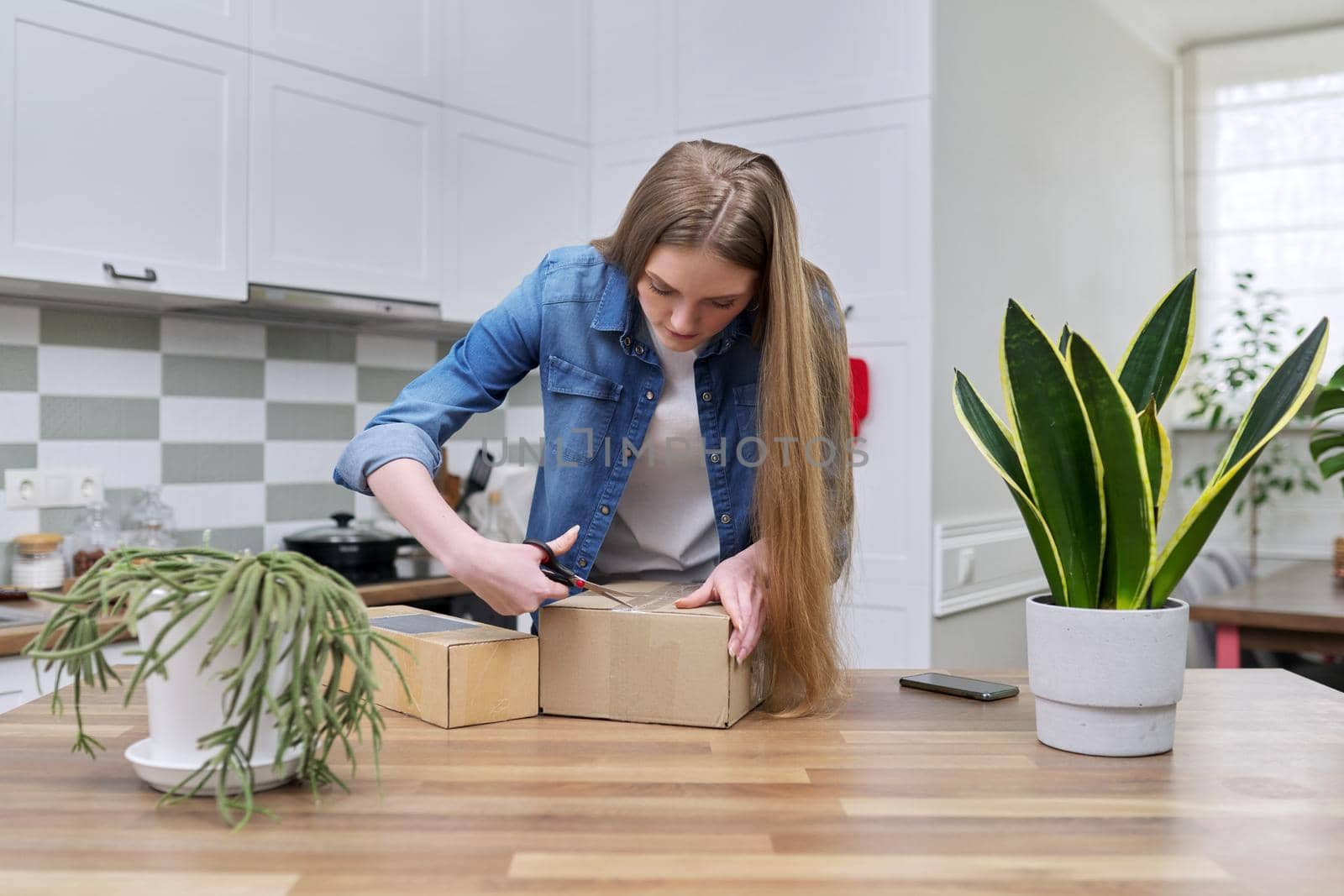 Young happy woman unpacking cardboard boxes, unboxing expected postal parcel by VH-studio