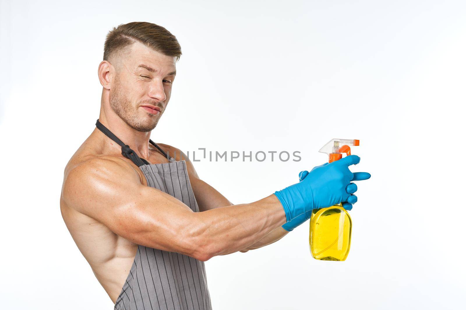 man in apron detergent cleaning service light background. High quality photo