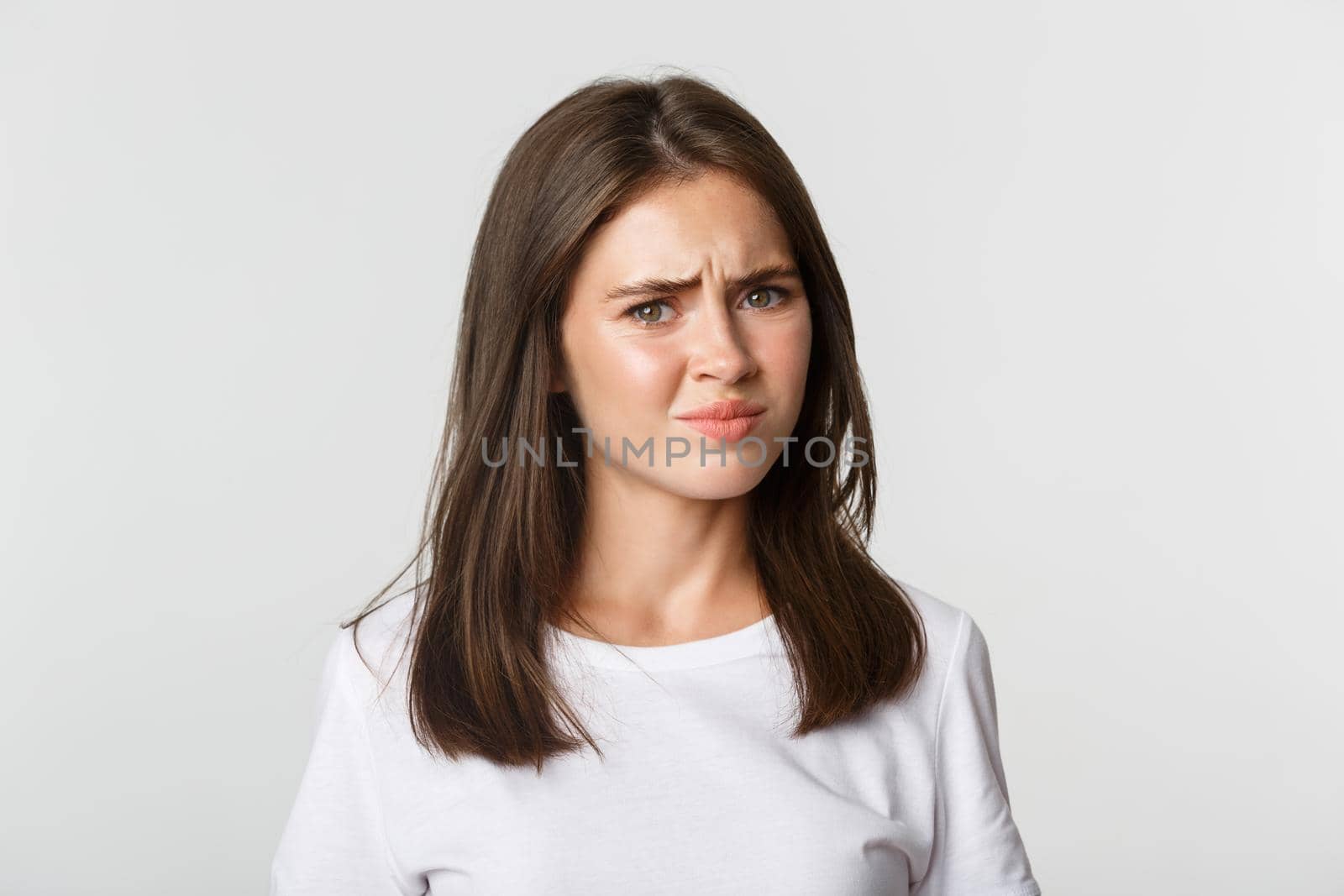 Close-up of skeptical and displeased attractive girl shaking head in rejection, frowning disappointed.