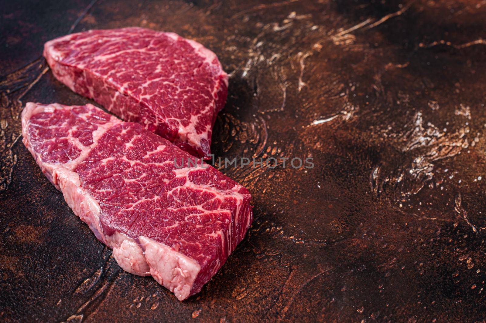 Raw Denver steak Marble beef meat. Dark background. Top view. Copy space.