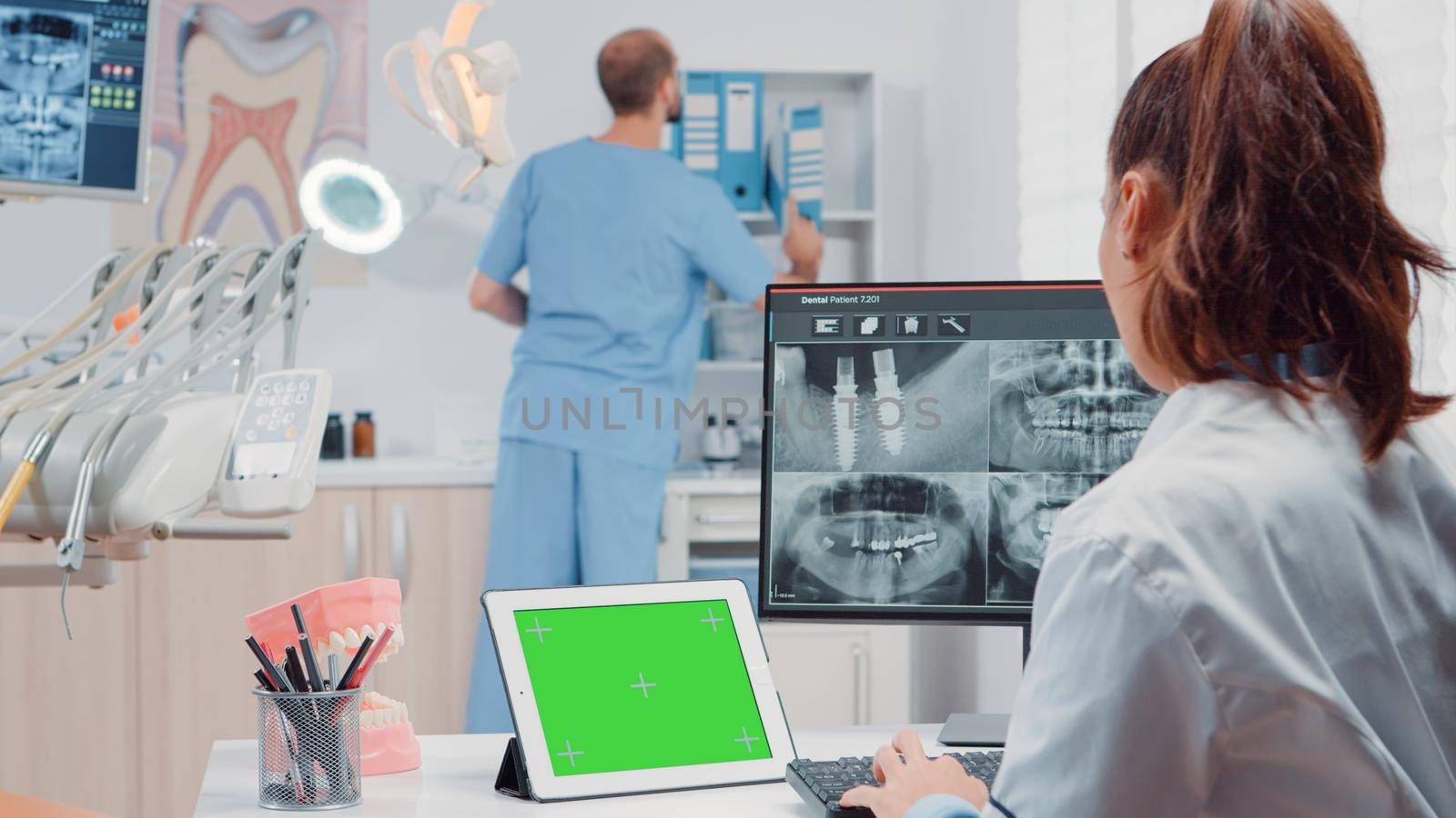 Orthodontist using horizontal green screen on tablet by DCStudio