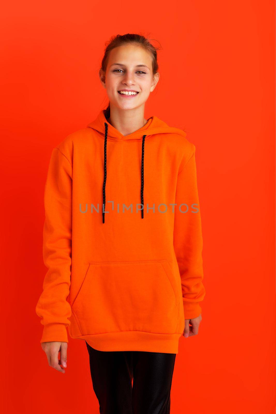 Stylish teenage girl in orange hoodie by kolesnikov_studio