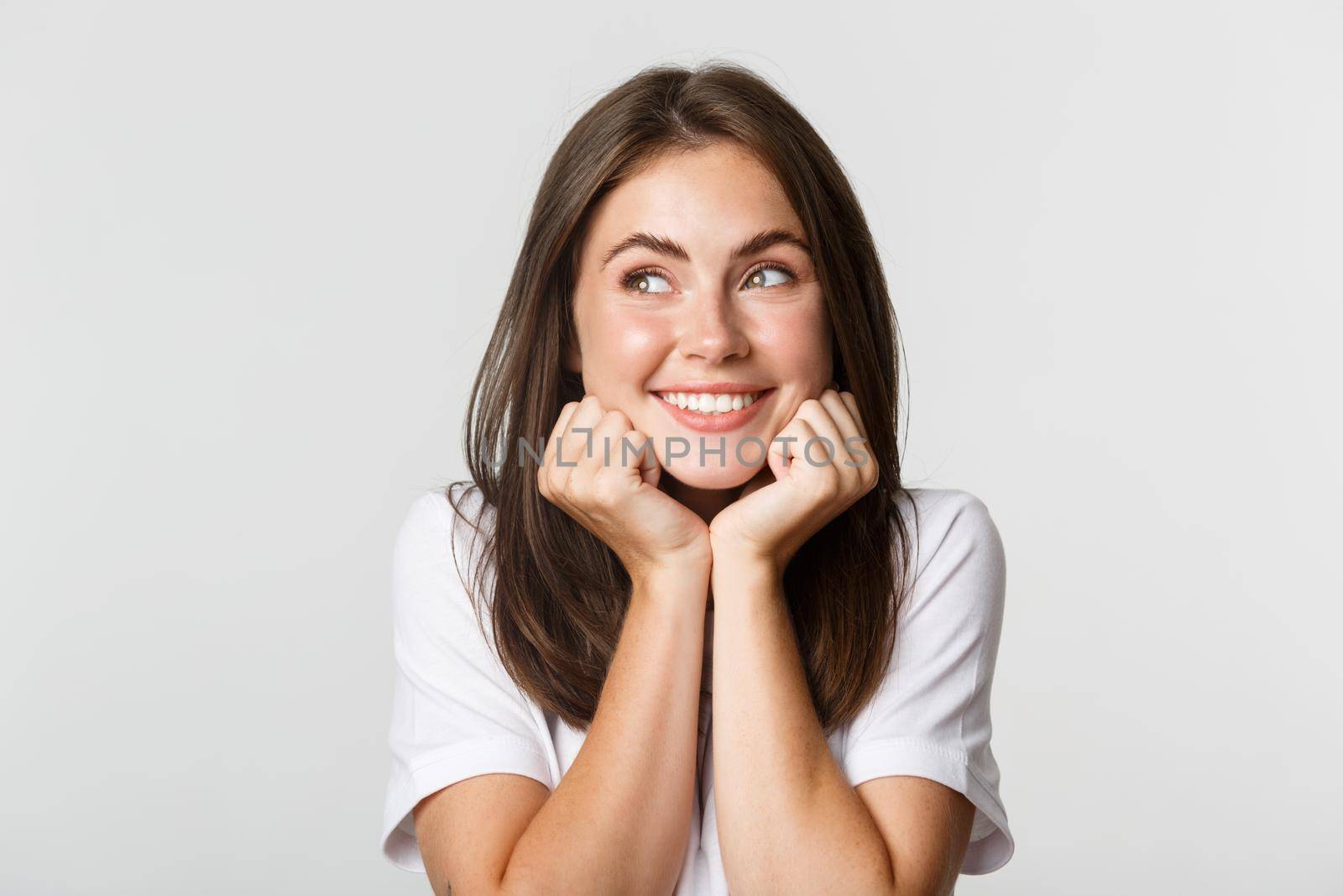 Close-up of adorable dreamy girl looking upper left corner nostalgic and smiling silly.