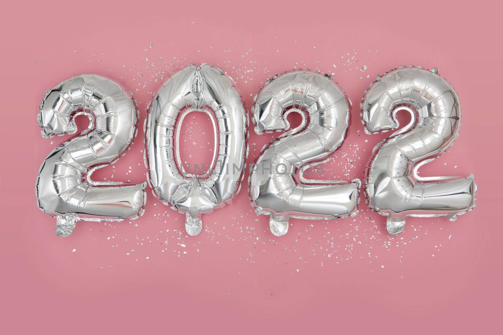 Silver foil balloons numeral 2022 and confetti Flat lay by Demkat