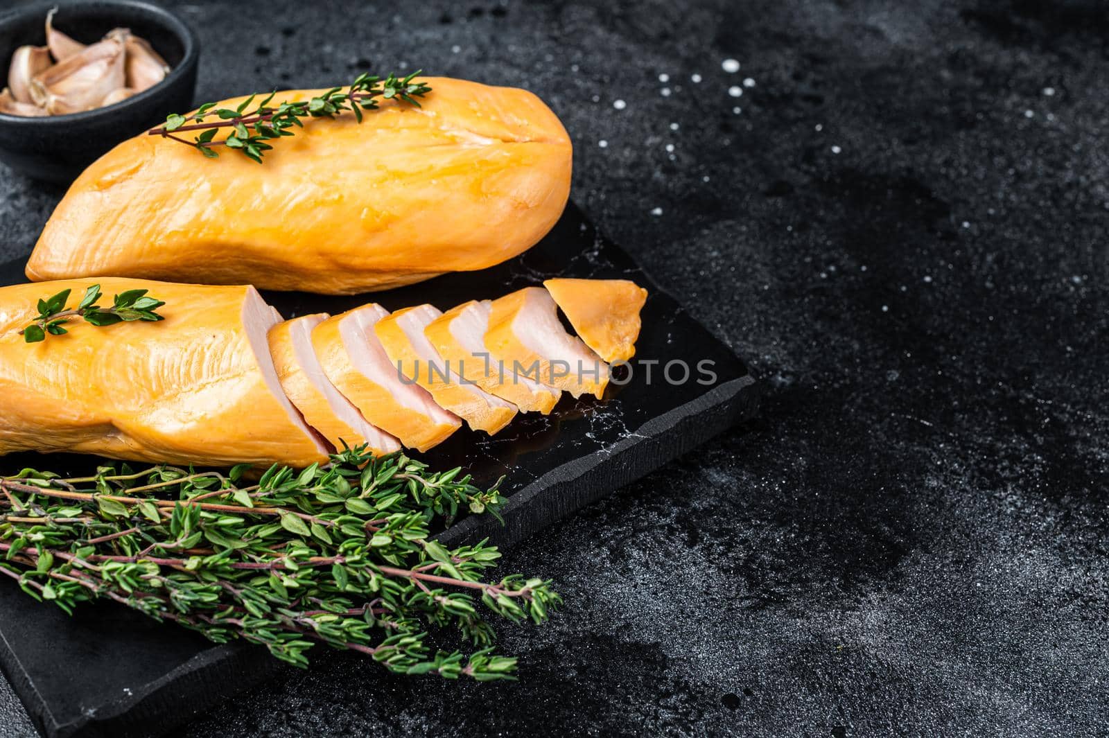 Smoked cut chicken breast fillet meat delicacy. Black background. Top view. Copy space.