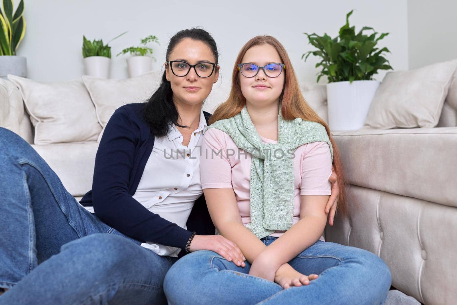 Portrait of happy mom and daughter, mother hugging her teenage daughter, sitting at home together. Mother's day, love, relationship, family concept