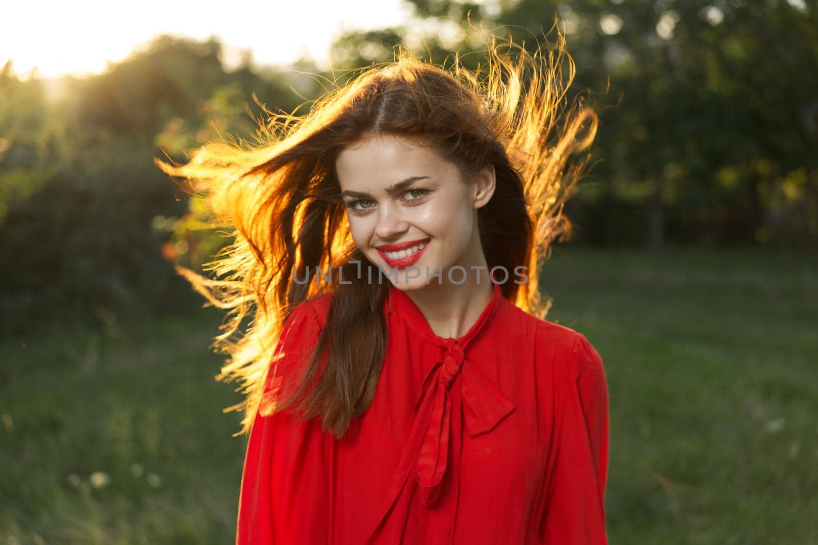 woman in red dress posing nature sun fun. High quality photo