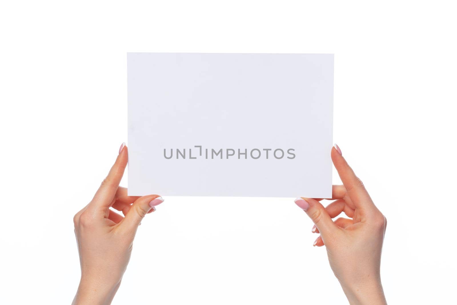 Female hand holding blank white sheet of paper isolated on white background