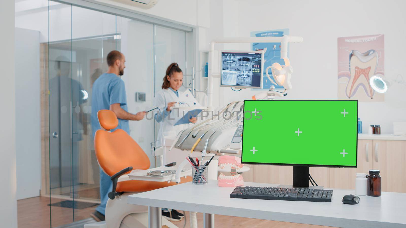 Horizontal green screen on computer in dentist office while specialists using equipment for dental care. Monitor with chroma key and isolated mockup template in office for teethcare.