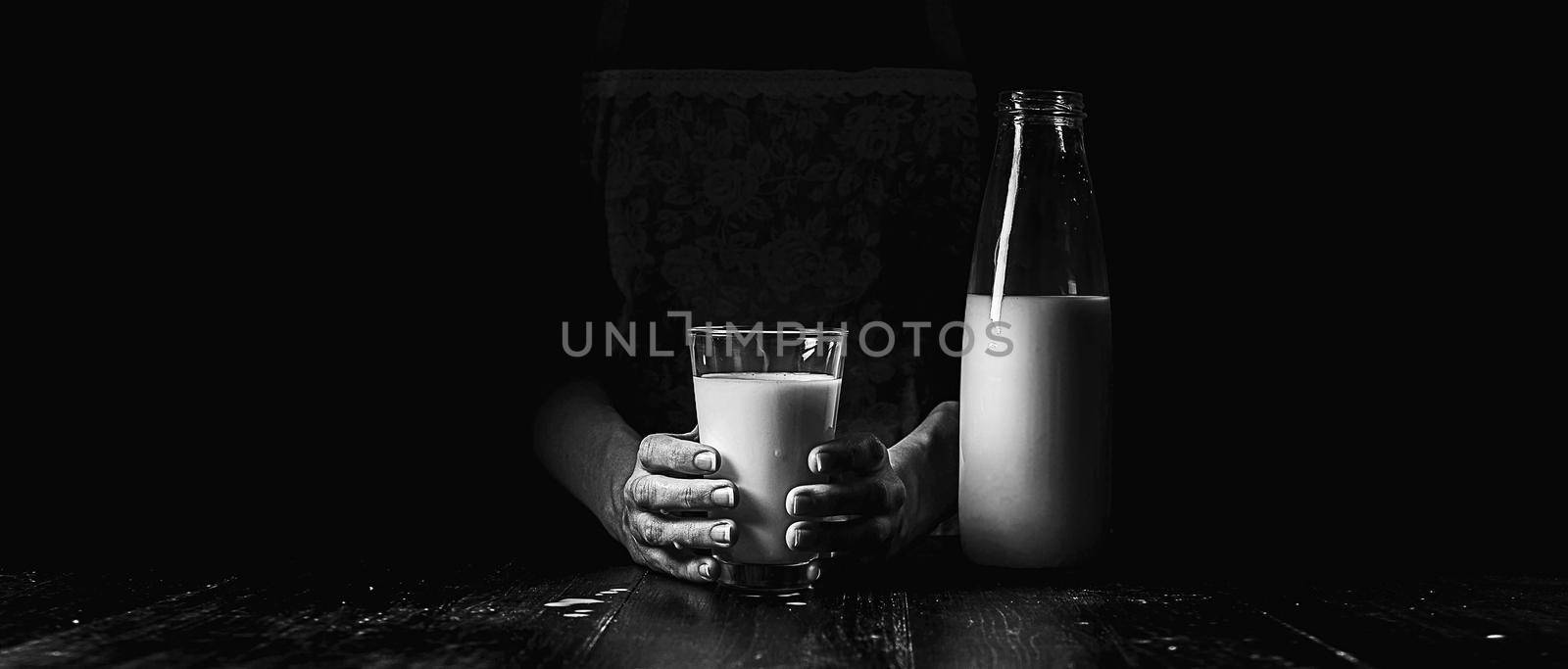 woman farmer with a glass of milk. concept problems in the agricultural sector. by vvmich