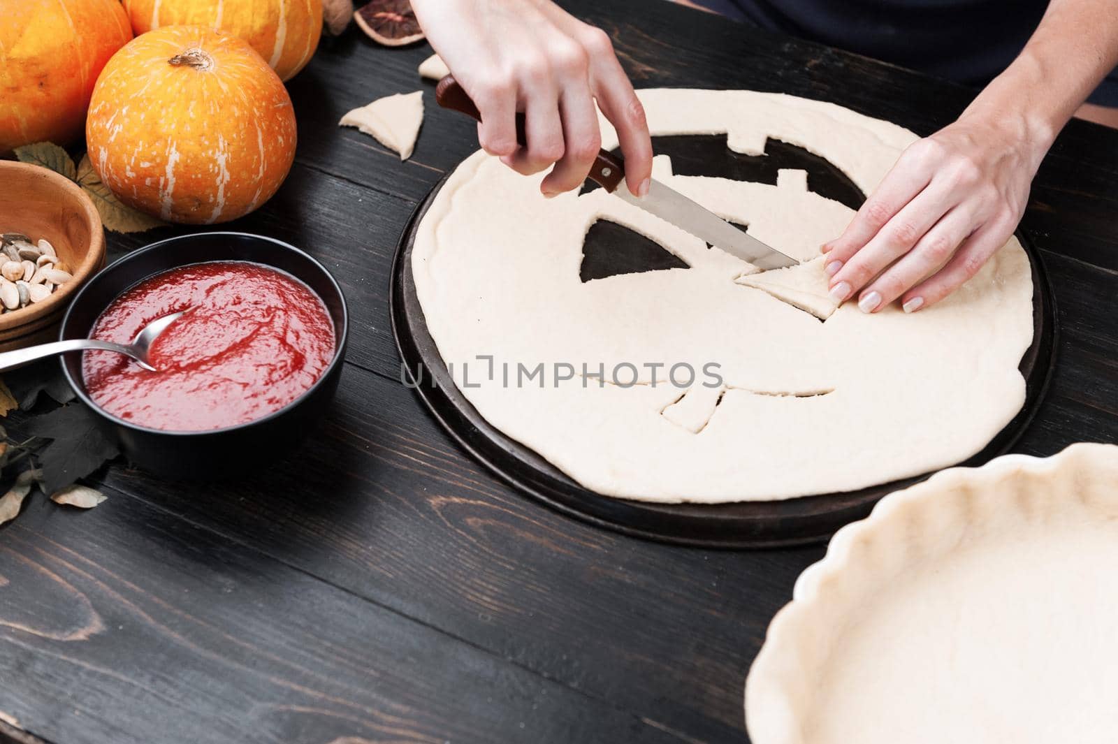 Chef cooks a pie for Halloween with a filling of pumpkin-strawberry jam and peaches by vvmich