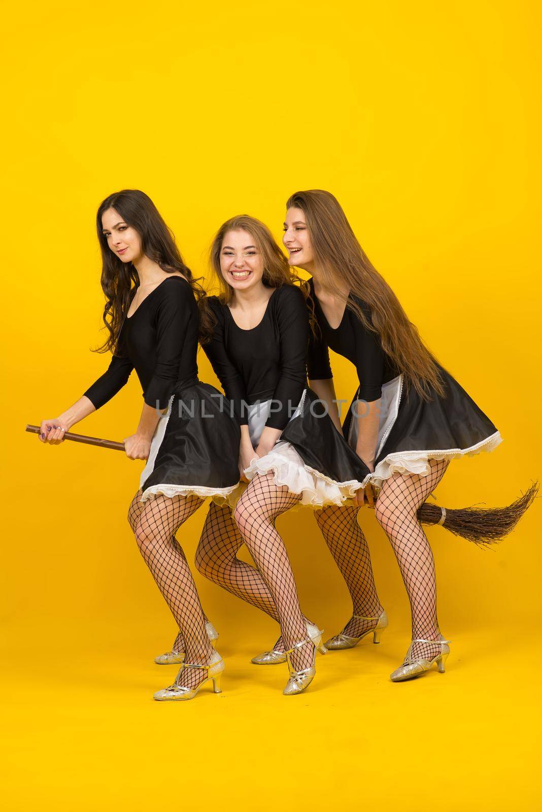 Three sexy maids on broomstick in the studio, witches, evil spirits.