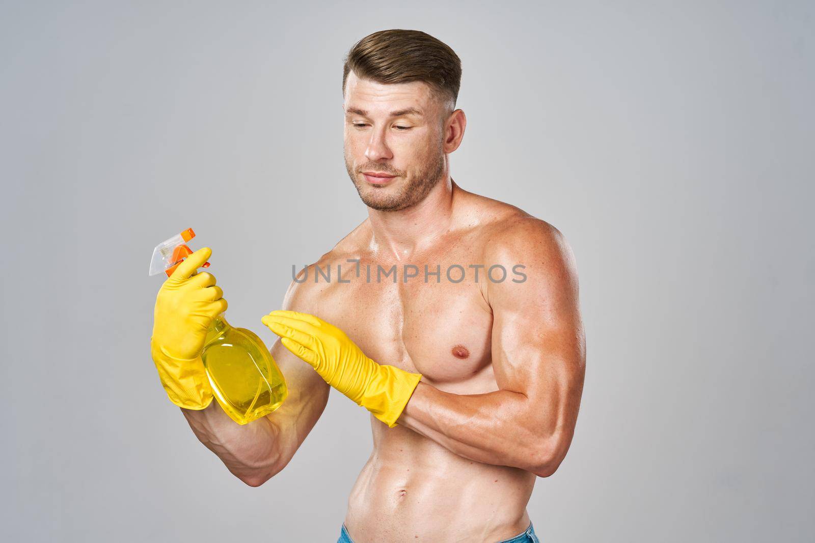 muscular man wearing rubber gloves posing homework. High quality photo