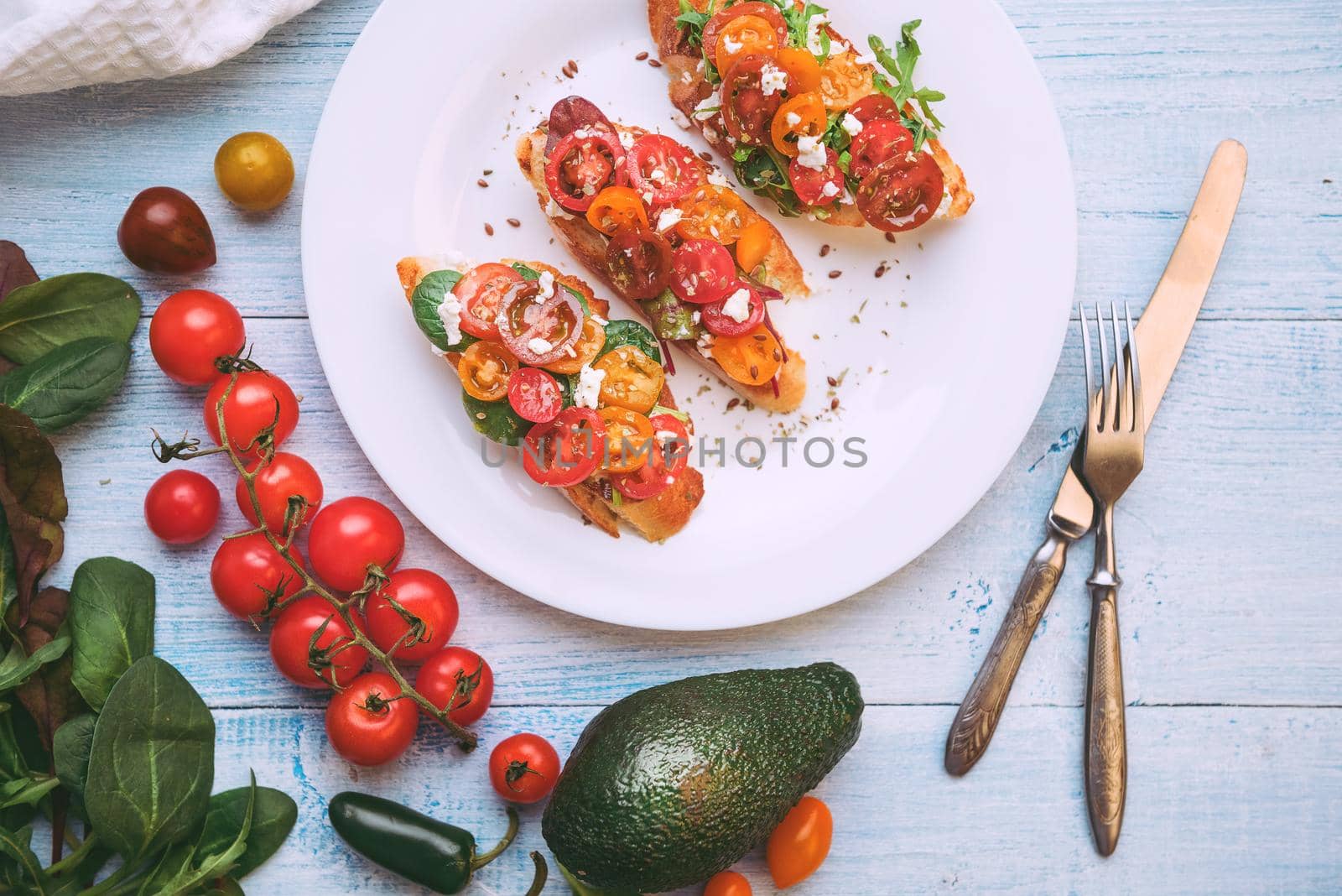 Bruschetta with cheese, basil, arugula and cherry tomatoes by vvmich