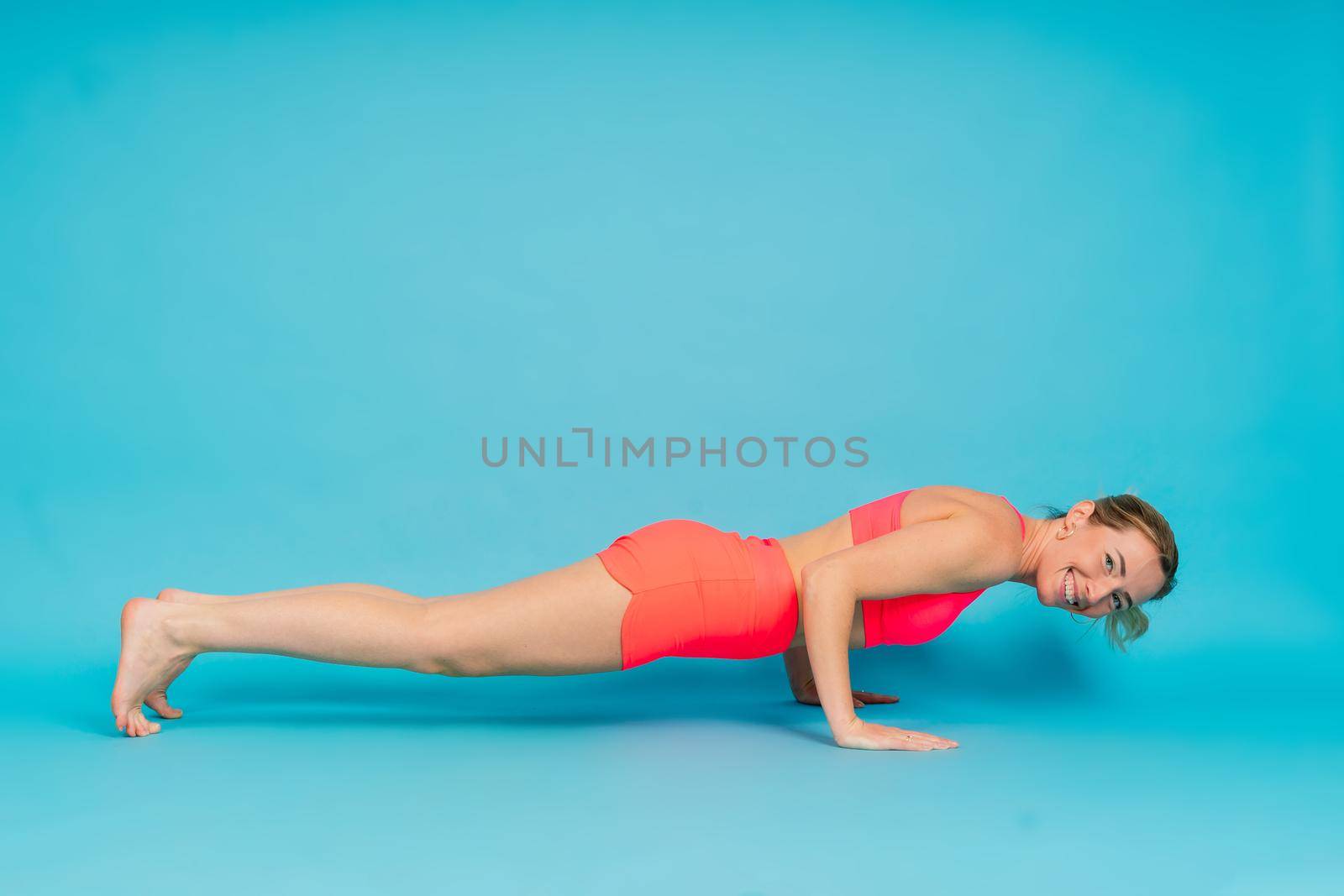 Beautiful female with dumbbells posing on a studio background