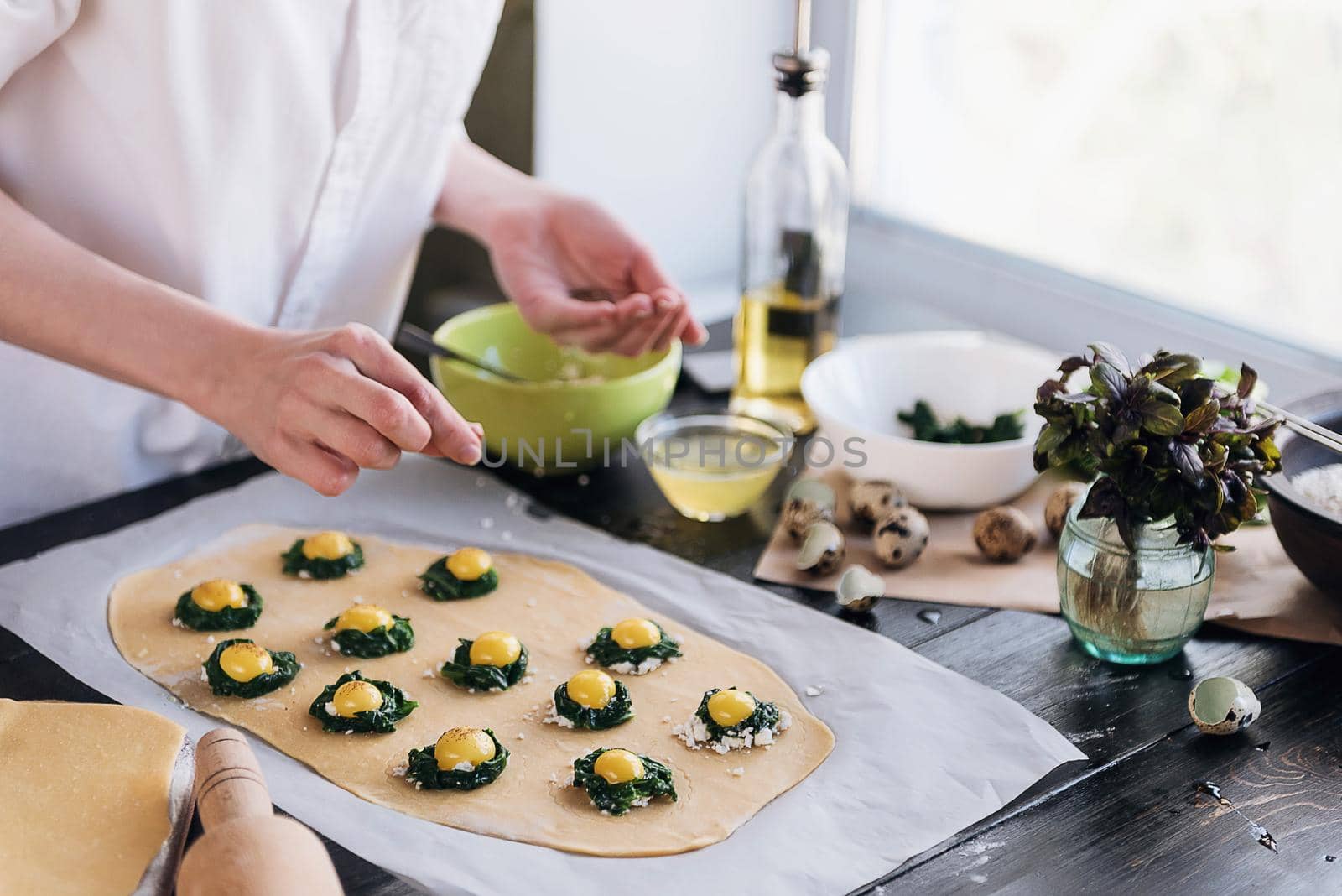 Step by step the chef prepares ravioli with ricotta cheese, yolks quail eggs and spinach with spices. The chef prepares the filling on the dough