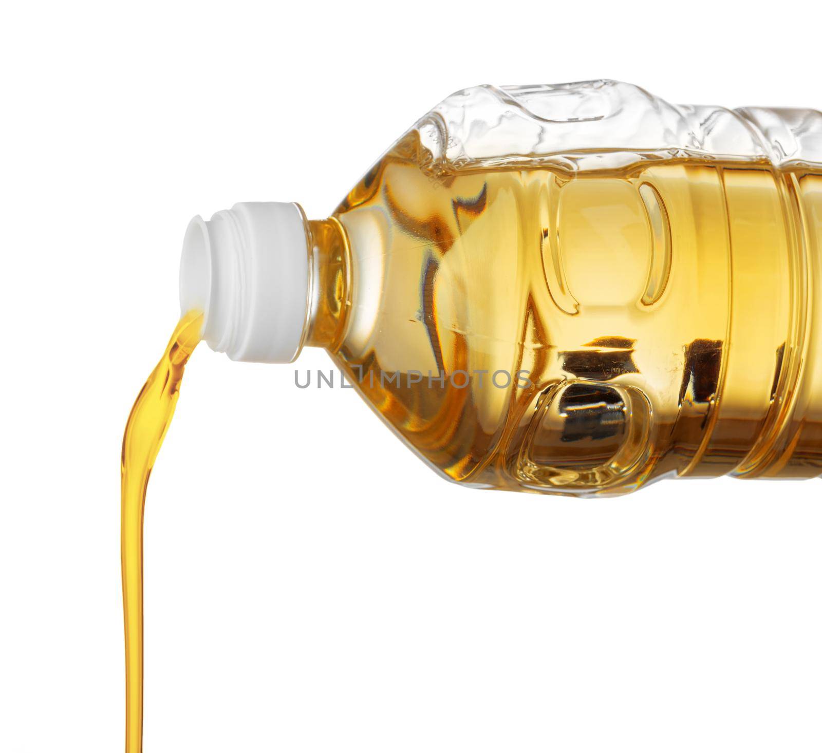 Pouring oil for cooking in a bottle isolated on white background. Close up.