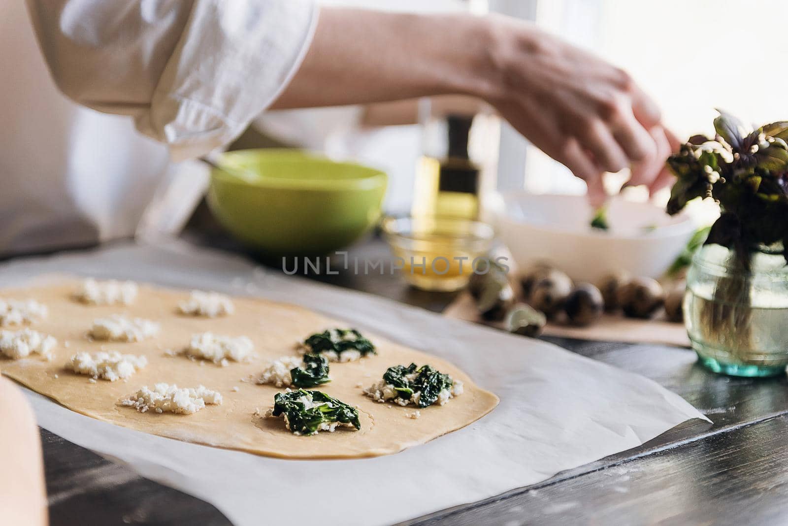 Step by step the chef prepares ravioli with ricotta cheese, yolks quail eggs and spinach with spices. The chef prepares the filling on the dough