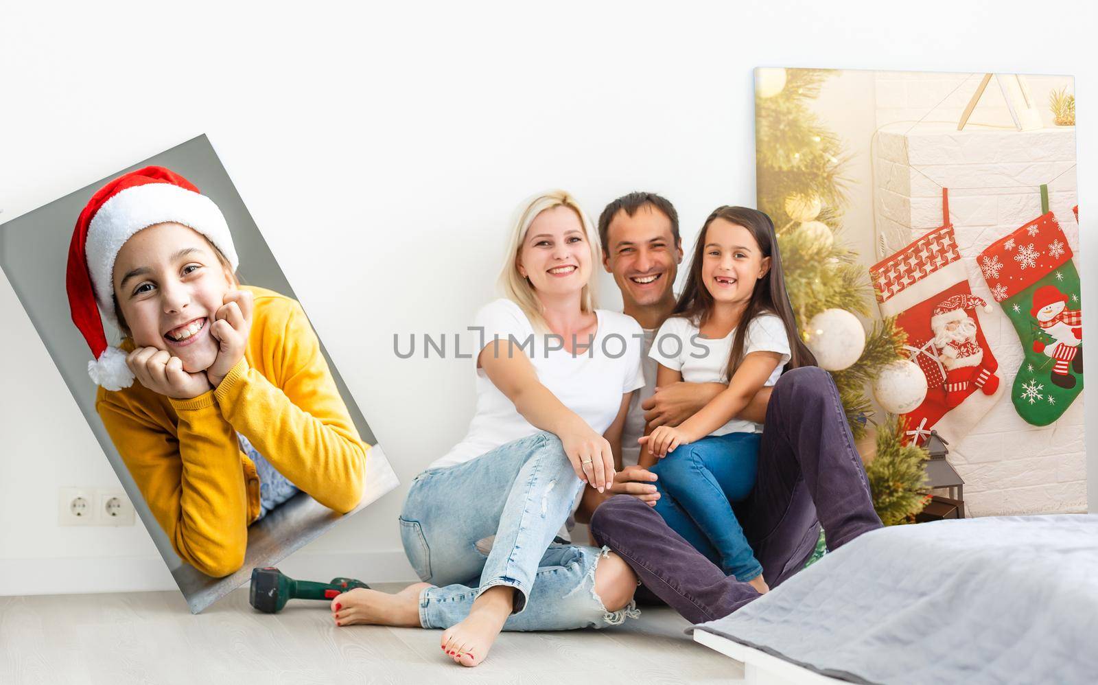 In new flat family hangs a large photo canvas on empty white wall at home by Andelov13