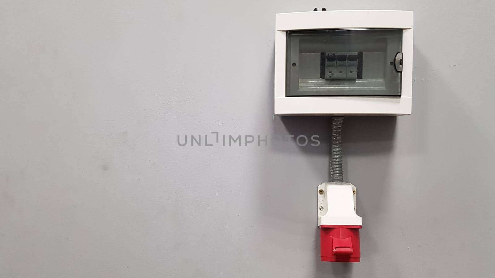 Three-phase 380 V high-voltage plug on a gray wall in a room with copy space