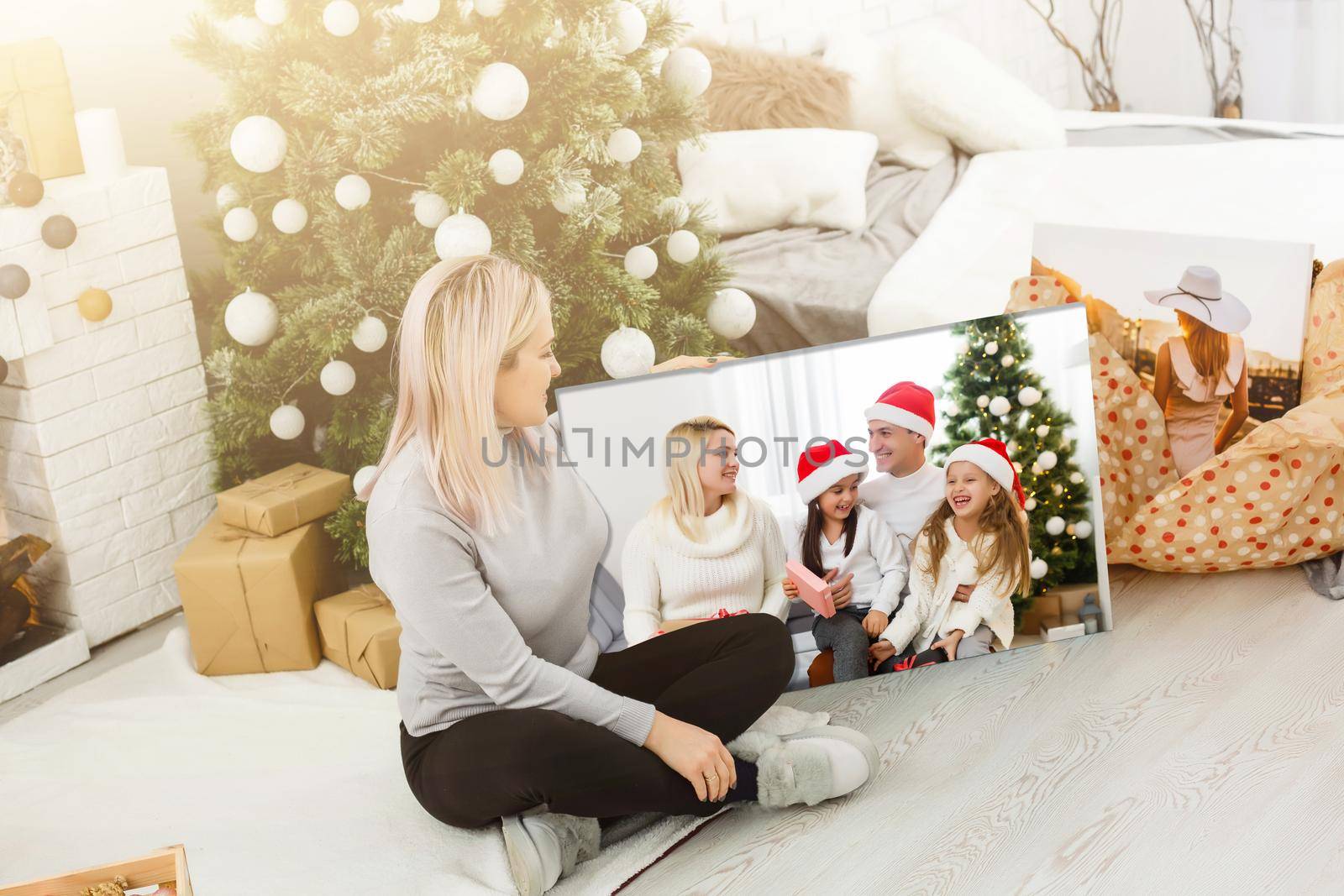 woman holding a photo canvas on the background of a Christmas interior.