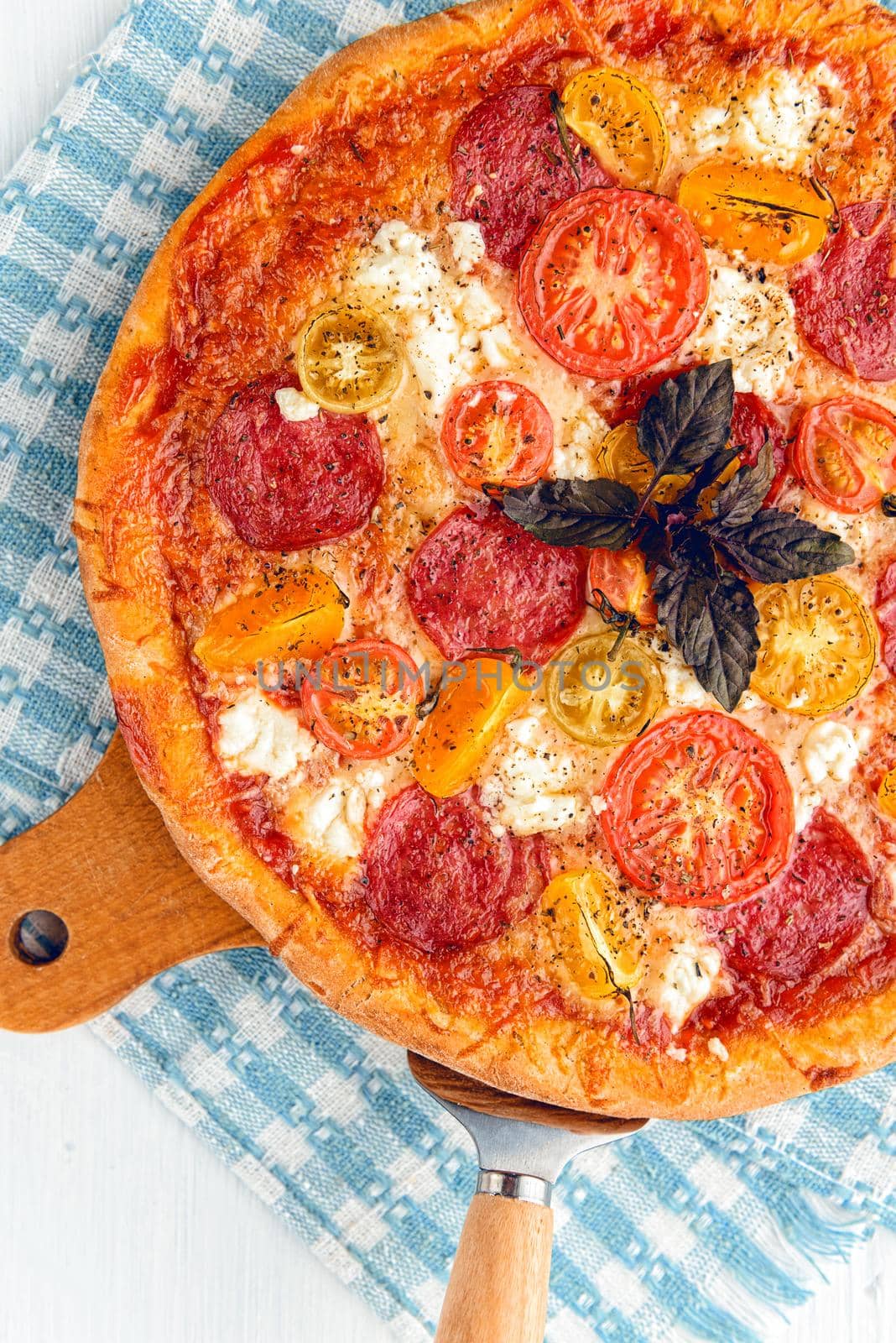 pepperoni italian pizza with salami and cheese on rustic wooden white background by vvmich