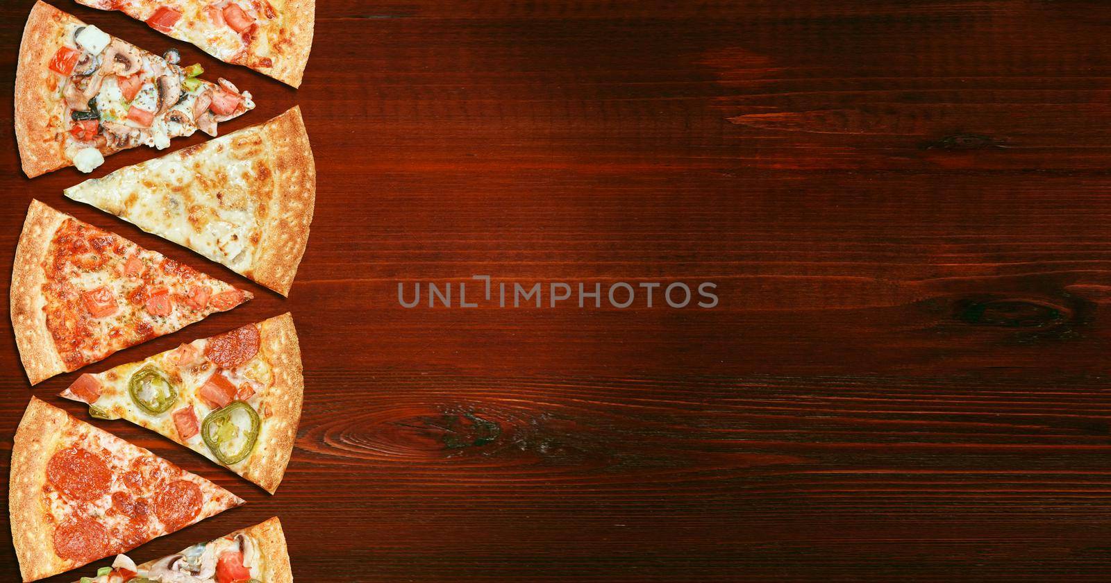 mix of eight different pizzas on a wooden background. menu concept of choice and diversity