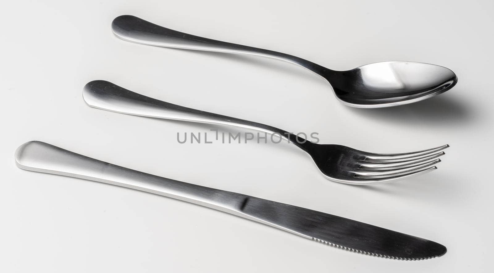 Spoon, fork and knife on a white background. Close up.