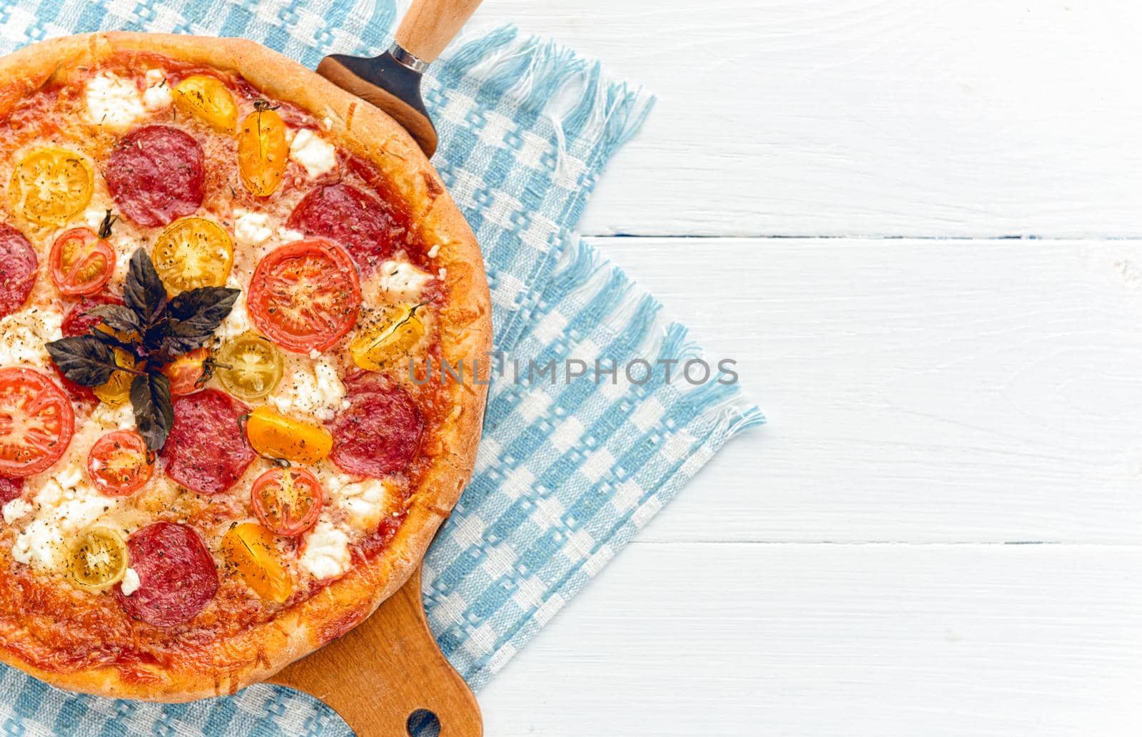 pepperoni italian pizza with salami and cheese on rustic wooden white background by vvmich