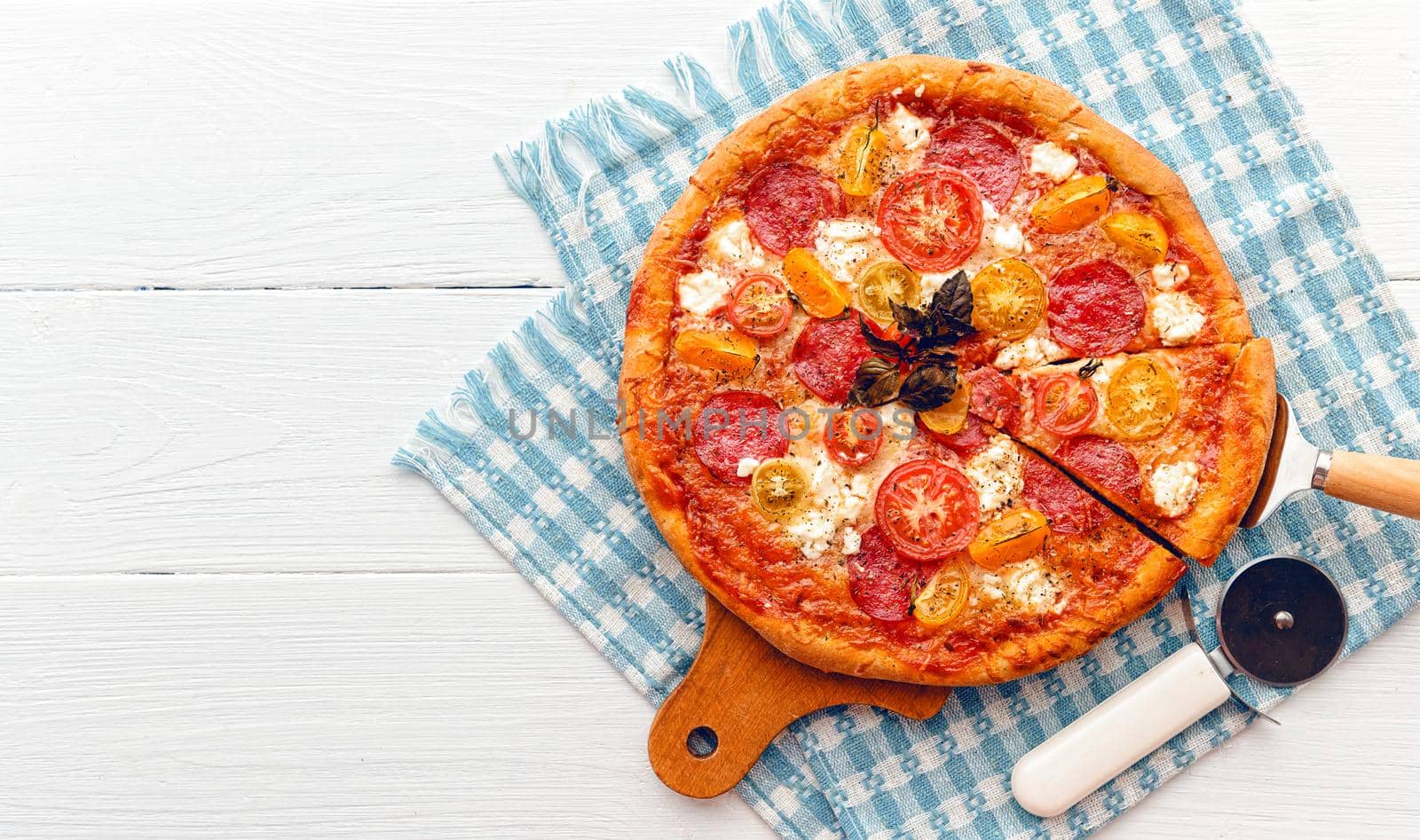 pepperoni italian pizza with salami and cheese on rustic wooden white background