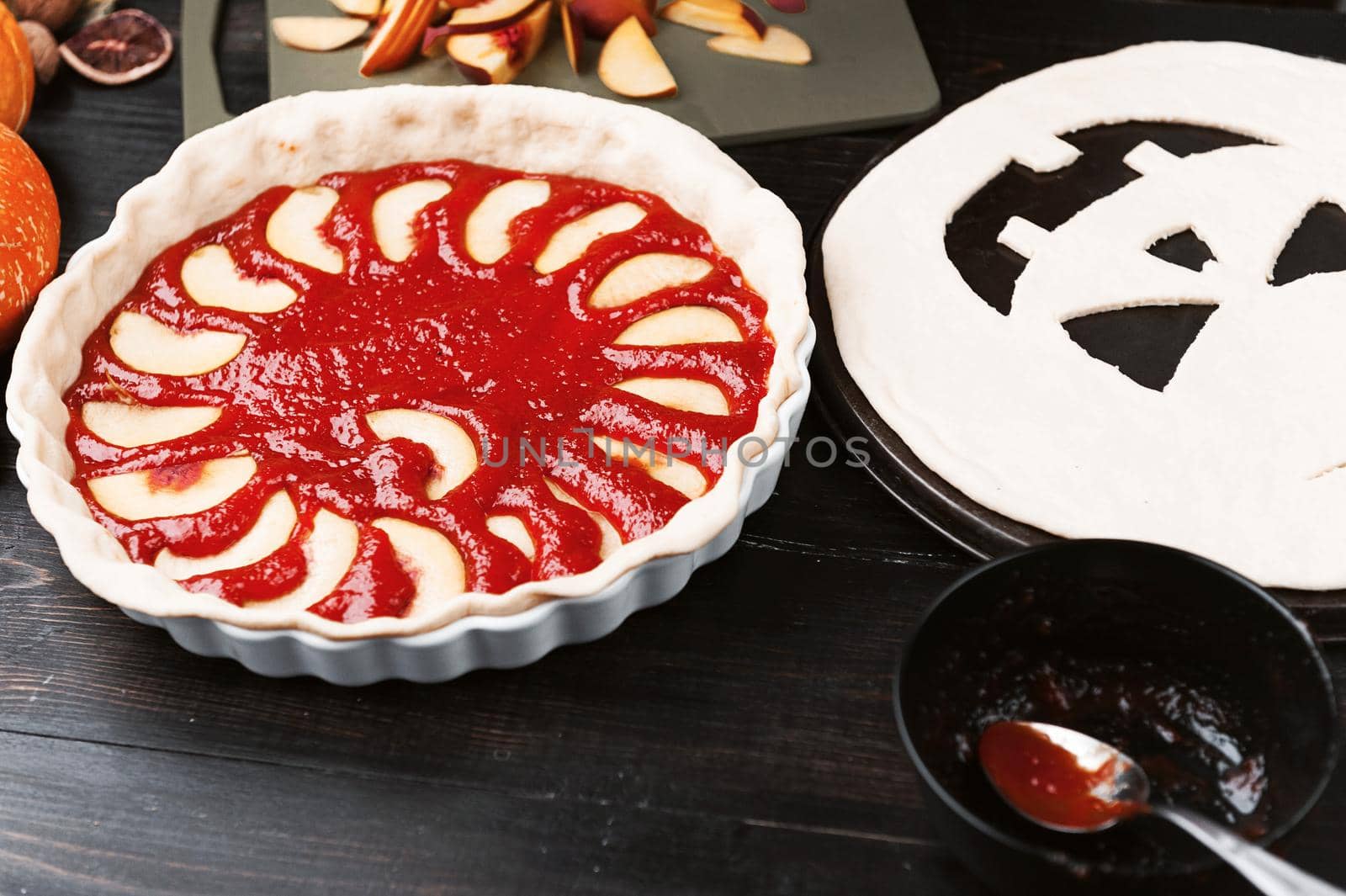 Chef cooks a pie for Halloween with a filling of pumpkin-strawberry jam and peaches