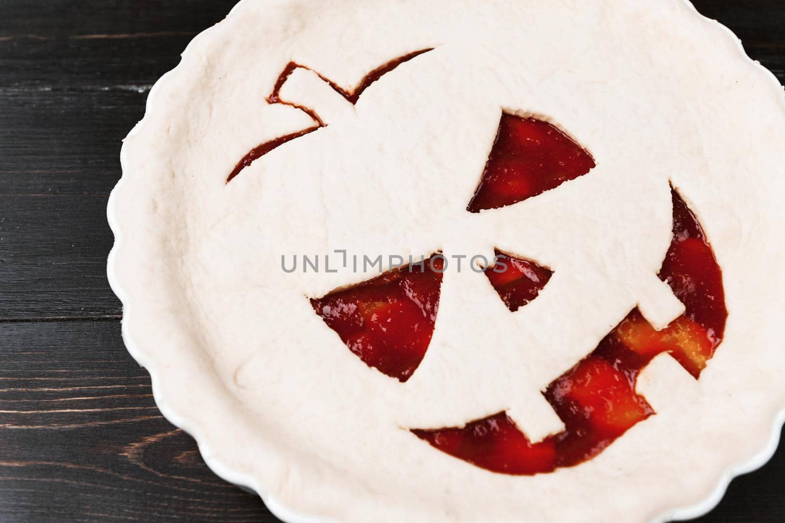 Chef cooks a pie for Halloween with a filling of pumpkin-strawberry jam and peaches