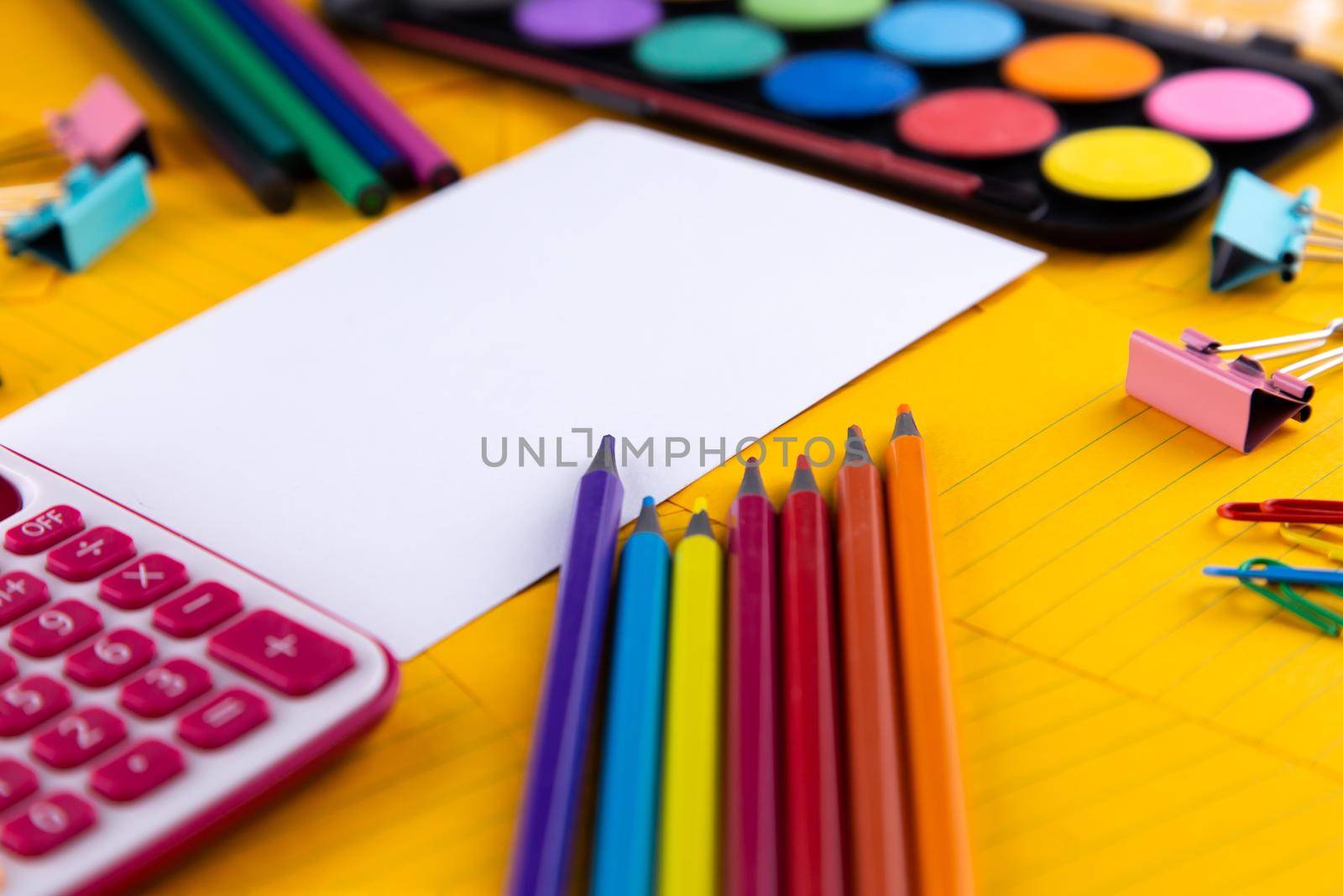 School office supplies stationery on a orange paper background with copy space. Back to school concept.