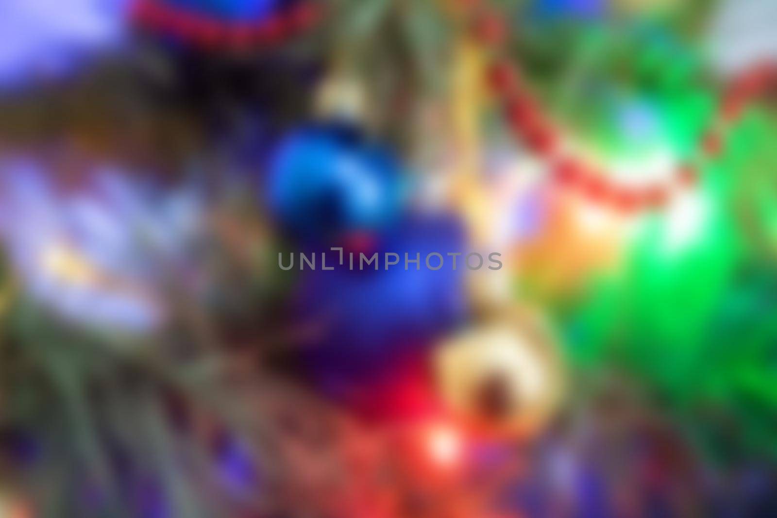Blurred christmas tree. Decorated with colorful christmas balls. Blurred background with an empty space for text.
